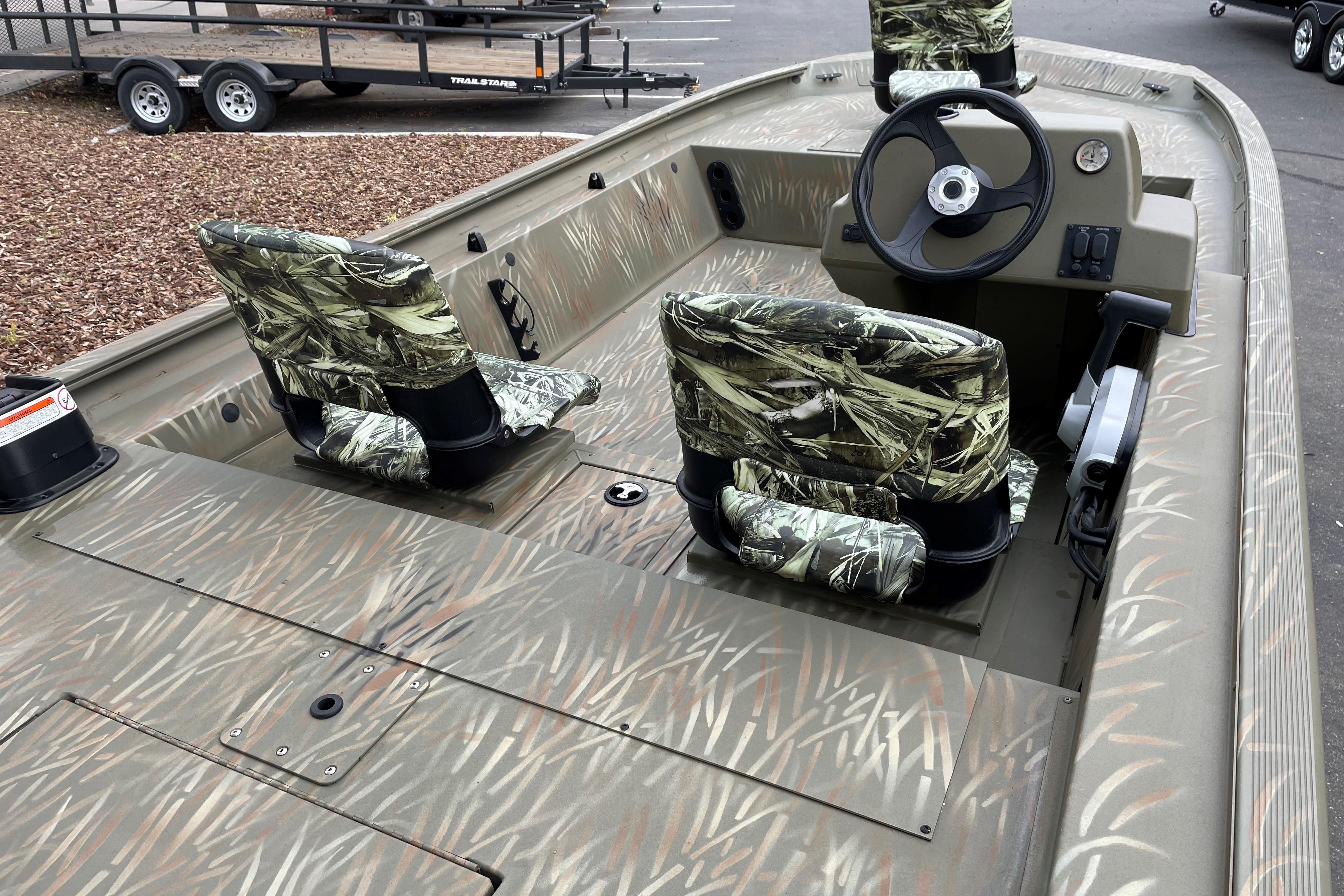2025 Tracker Grizzly 1754 SC boat with camouflage seats and steering console.