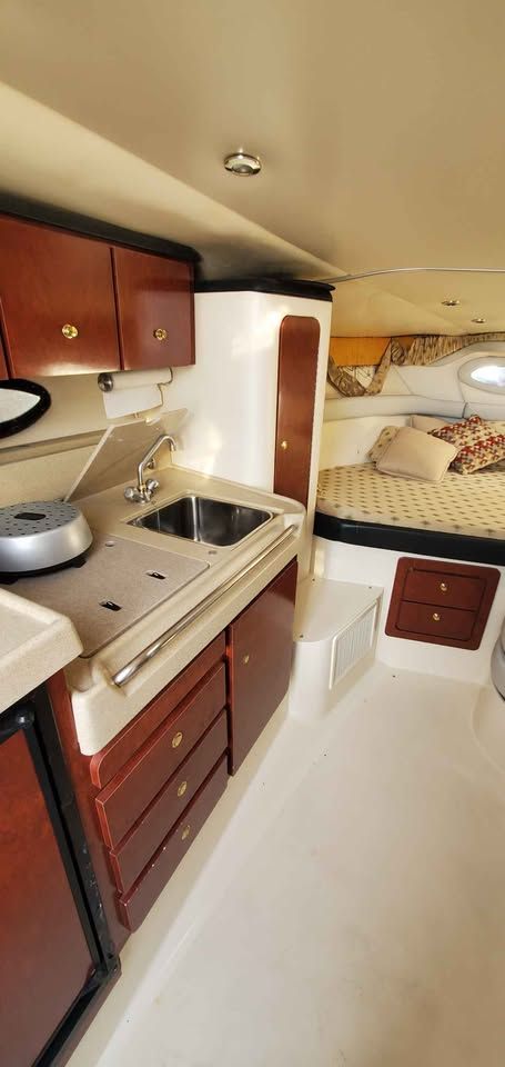 Interior of the 2002 Wellcraft 3300 Martinique with kitchen and sleeping area.