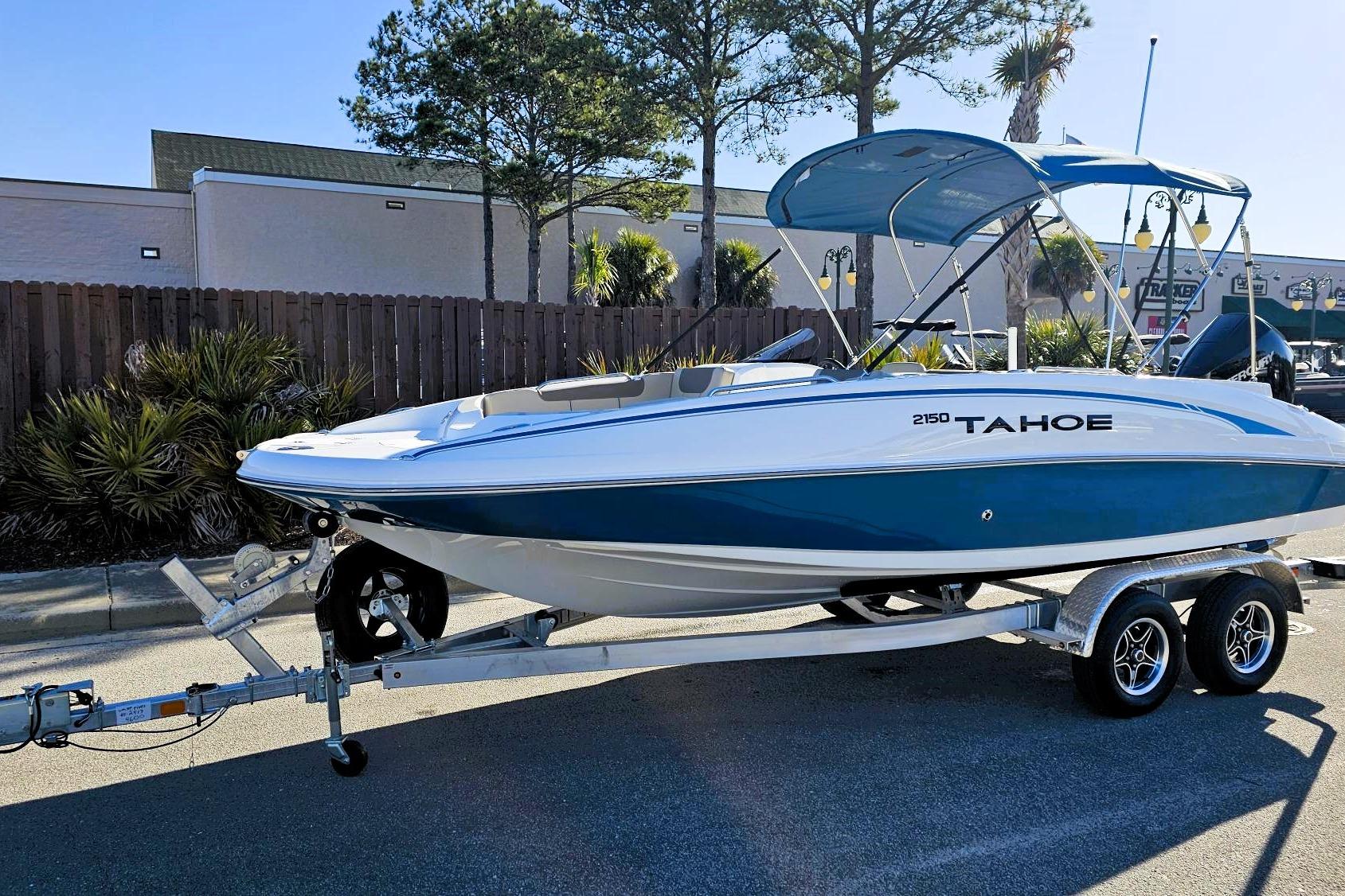 2026 Tahoe 2150 boat on trailer, blue and white design, parked outdoors.