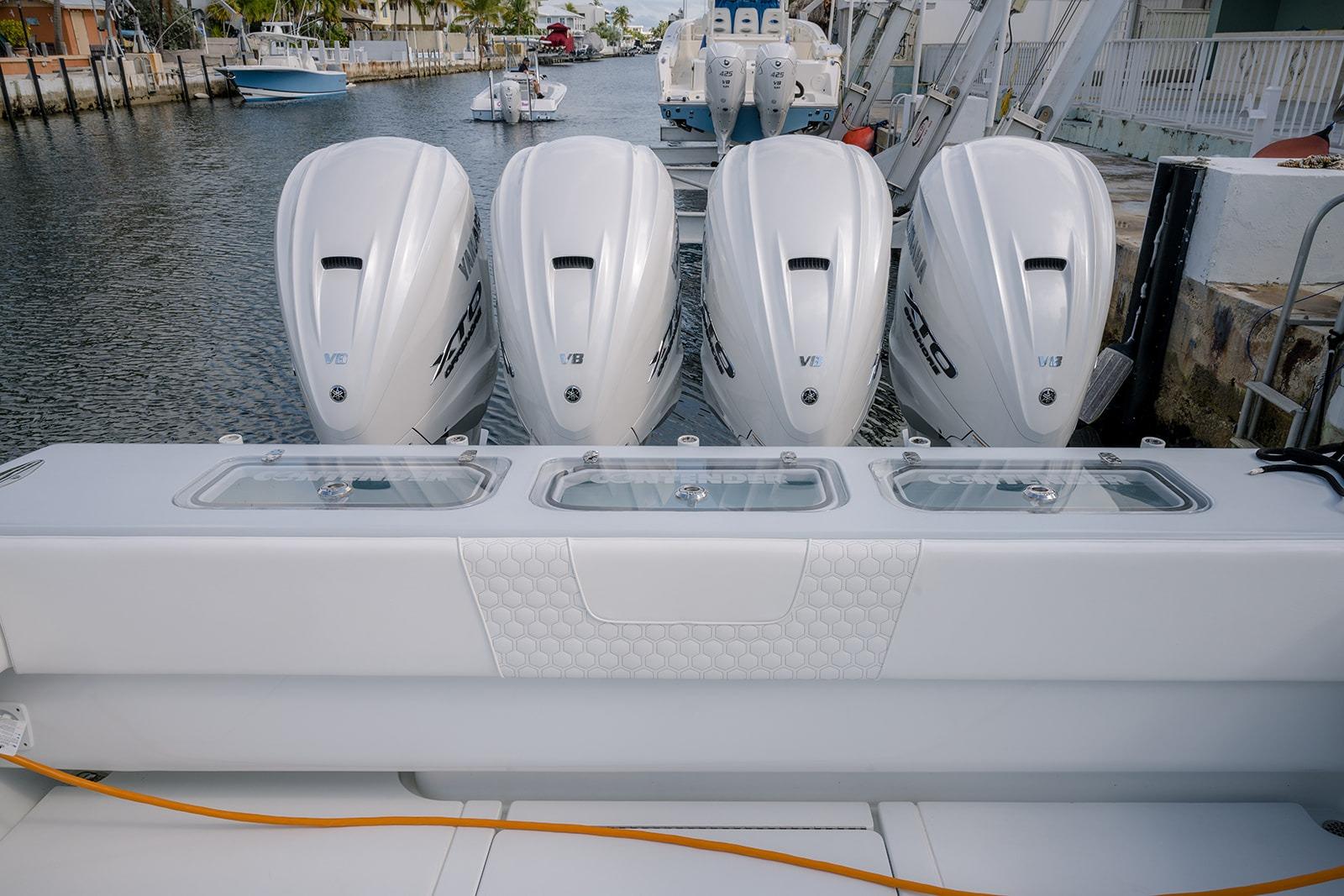 2024 Contender 44 ST boat with four powerful outboard engines docked by the water.