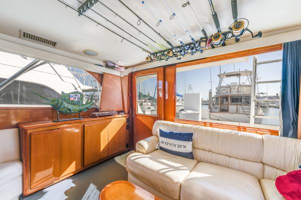Interior of 1999 Viking 47 Convertible yacht with fishing rods and comfortable seating.