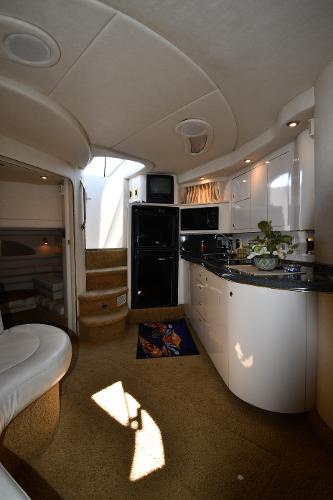 Interior of 1997 Sea Ray 400 Sundancer yacht with modern kitchen and cozy seating area.