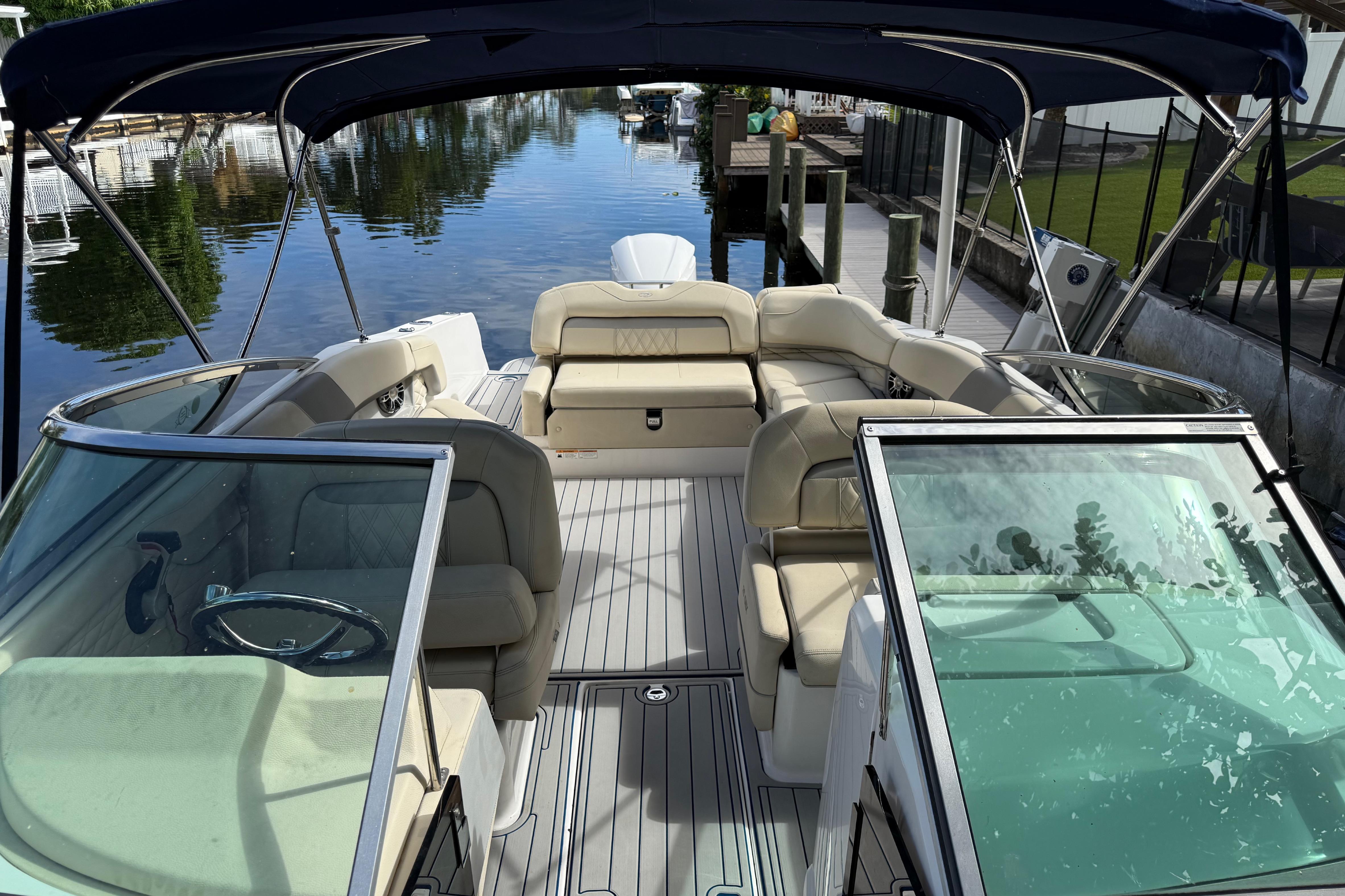 2021 Regal 26 OBX boat with spacious seating and canopy, docked by a serene waterway.