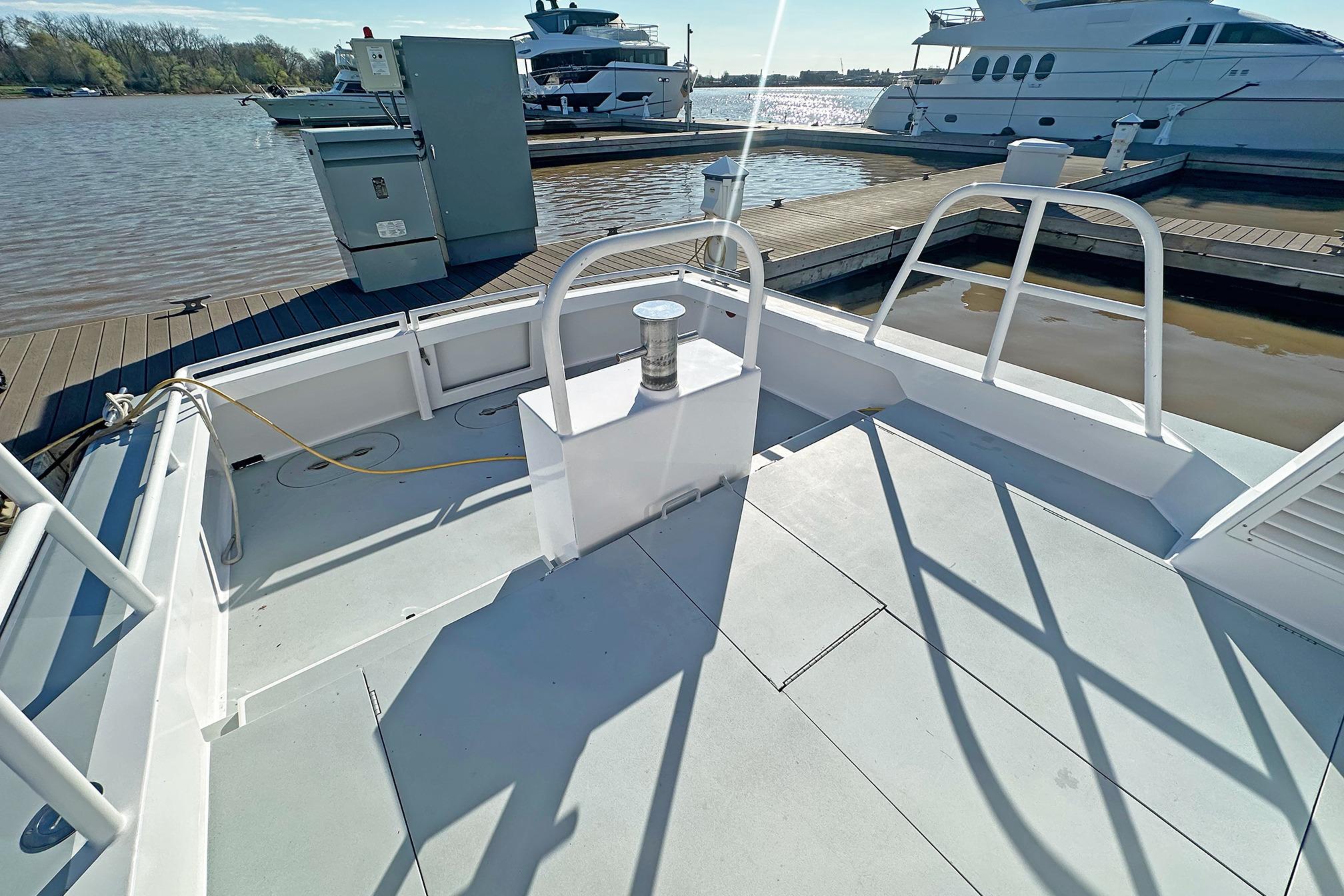 Boston Whaler 36 Defiance 1990 docked, showcasing spacious deck and marina view.