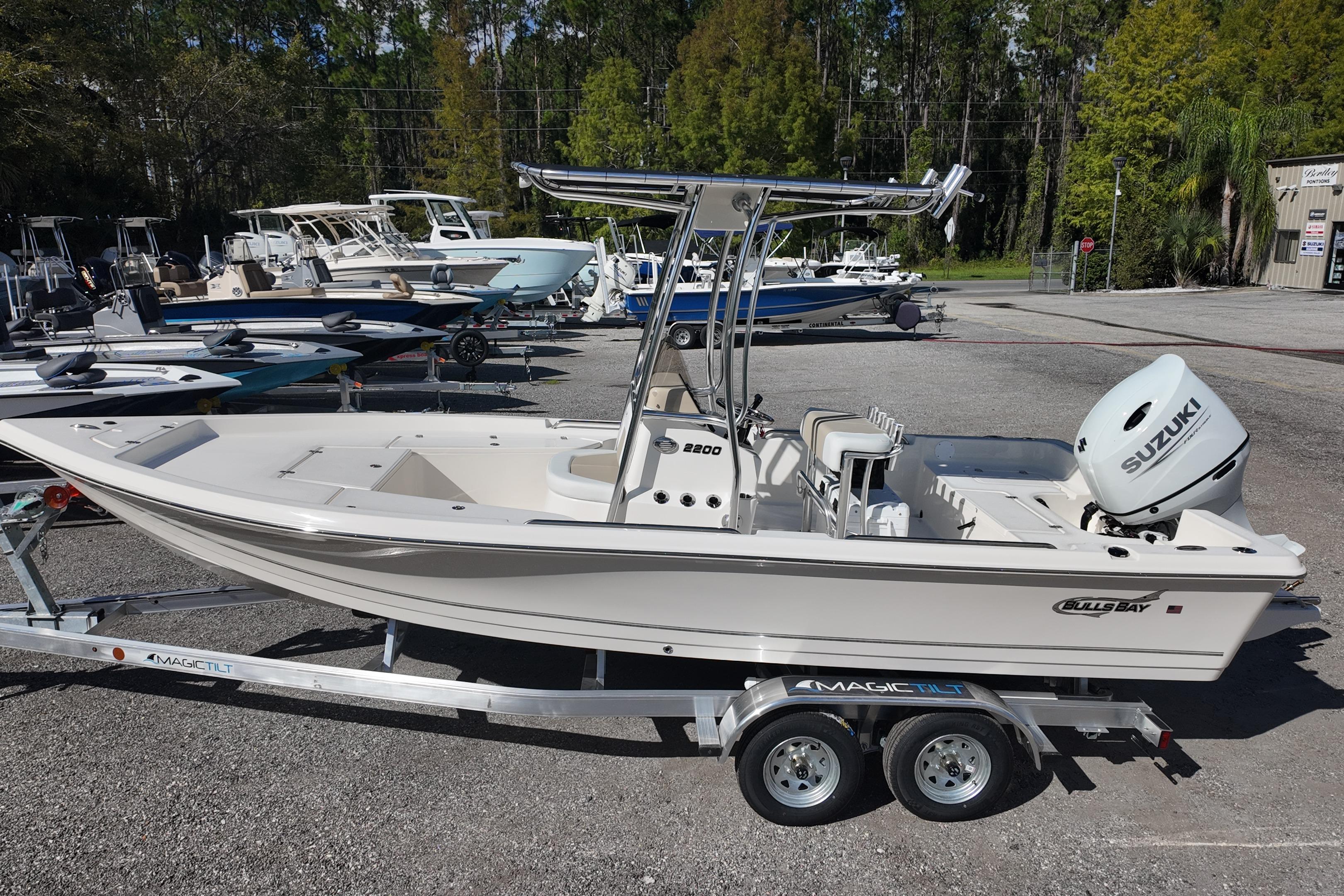2026 Bulls Bay 2200 boat on trailer with Suzuki outboard motor, parked outdoors.