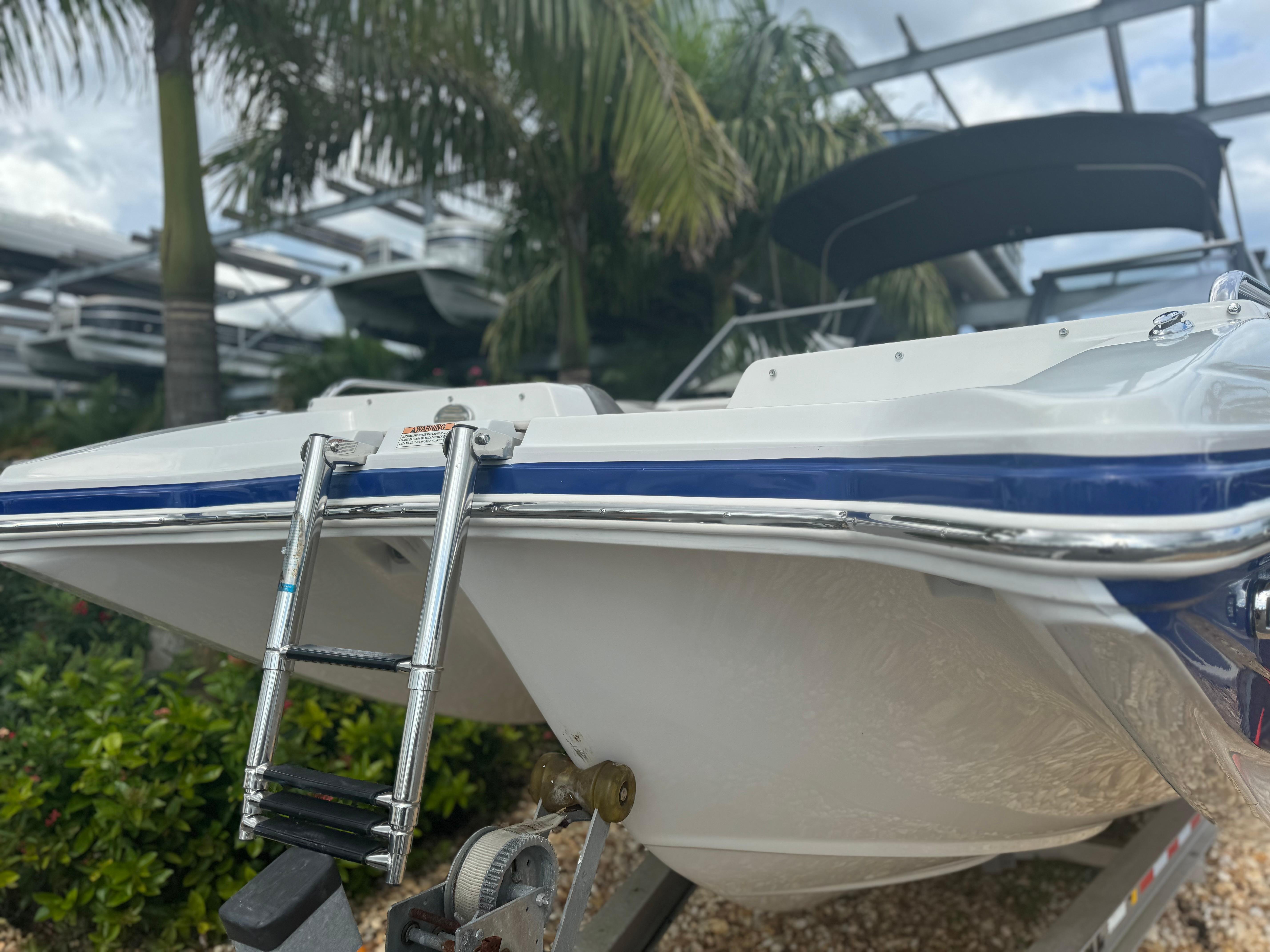 2017 Starcraft 230 OB SCX EXT boat with ladder, parked outdoors.