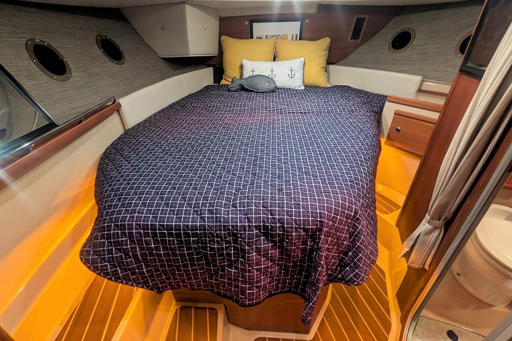 Cozy cabin interior of 2015 Ranger Tugs R-29 S with nautical-themed bedding.