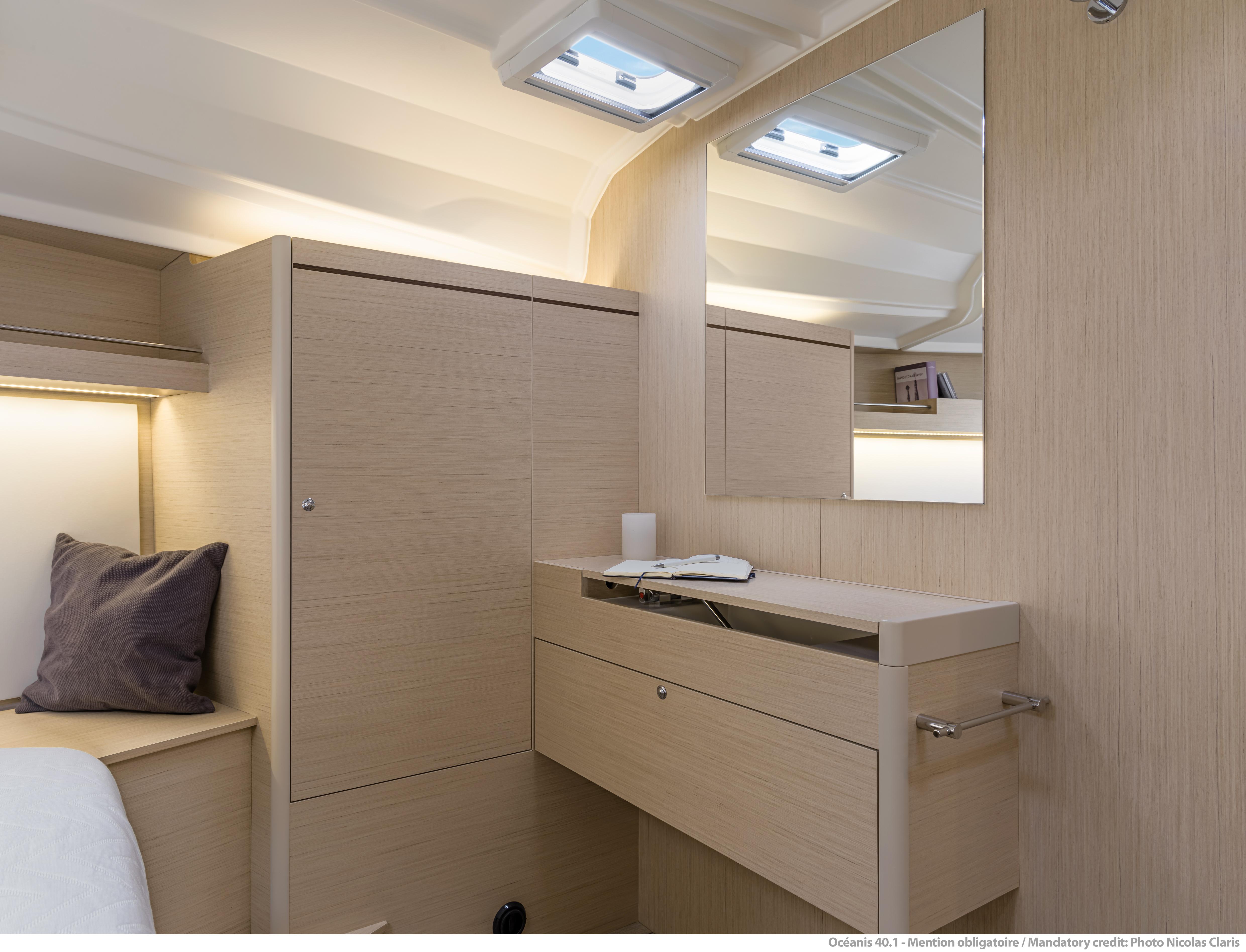 Interior of 2025 Beneteau Oceanis 40.1 yacht, featuring modern wood cabinetry and mirror.