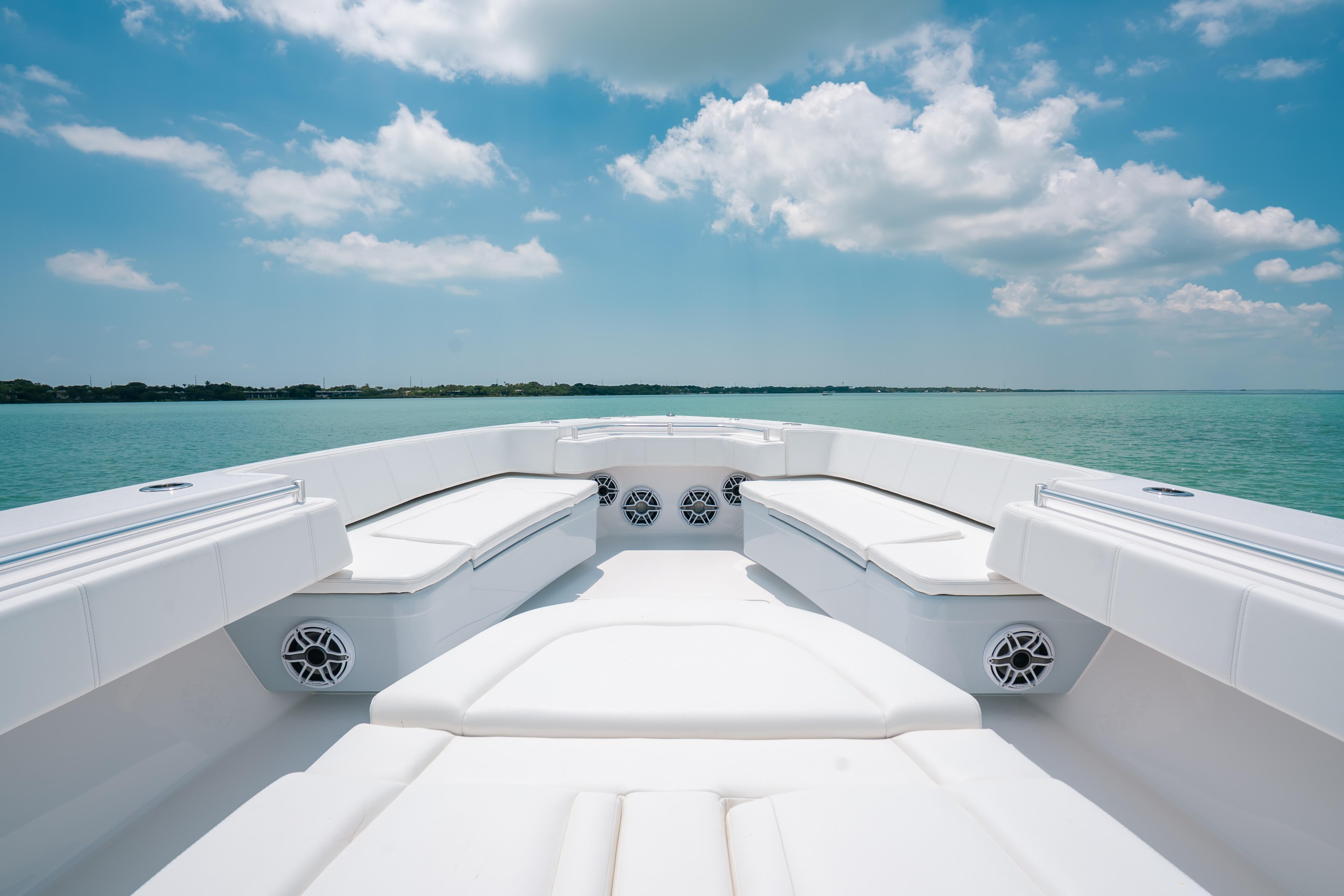 2025 Contender 44 ST boat interior with white seating, set against a serene ocean backdrop.