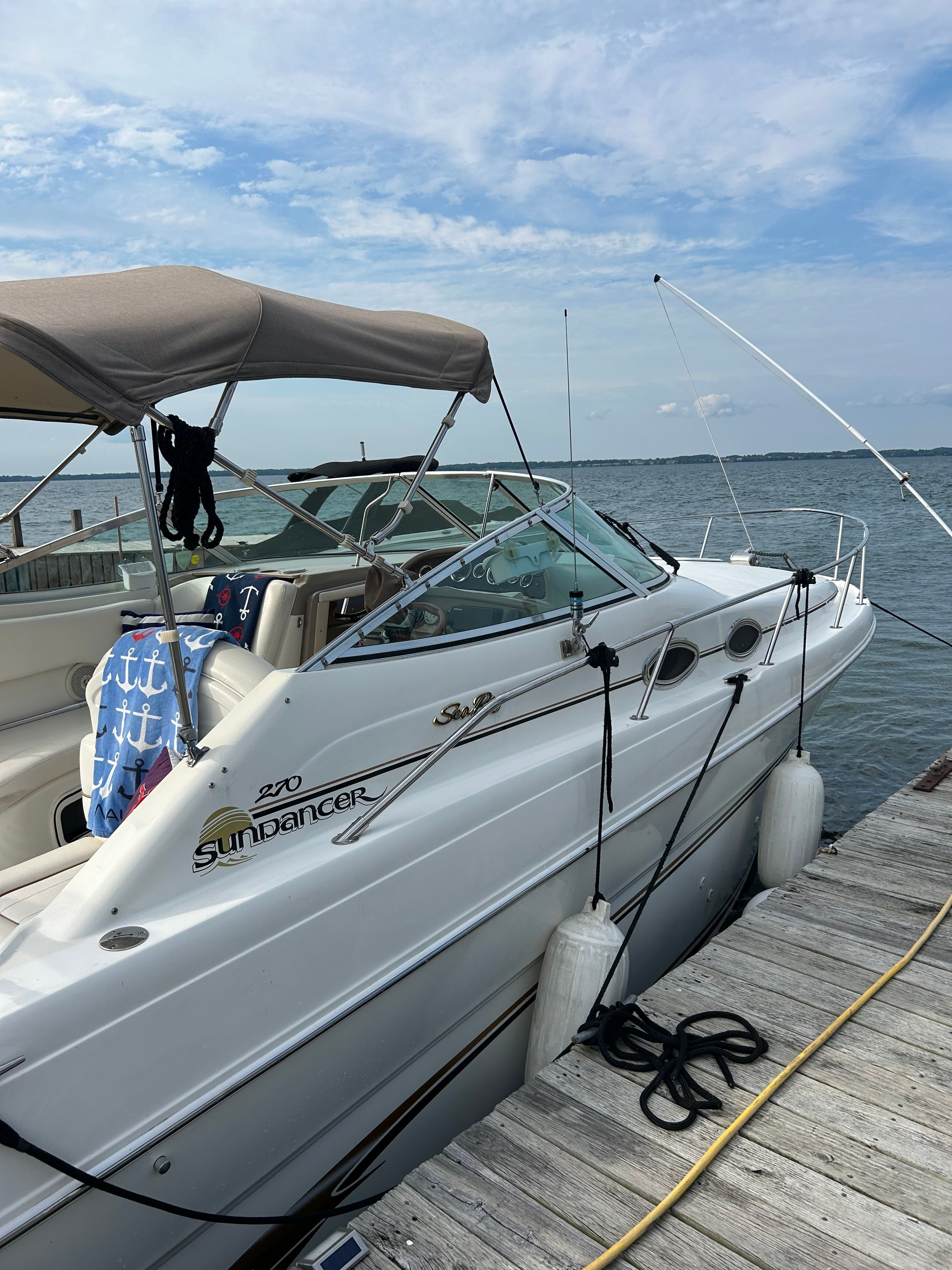 A 1999 Sea Ray 270 Sundancer Special Edition docked at a wooden pier.