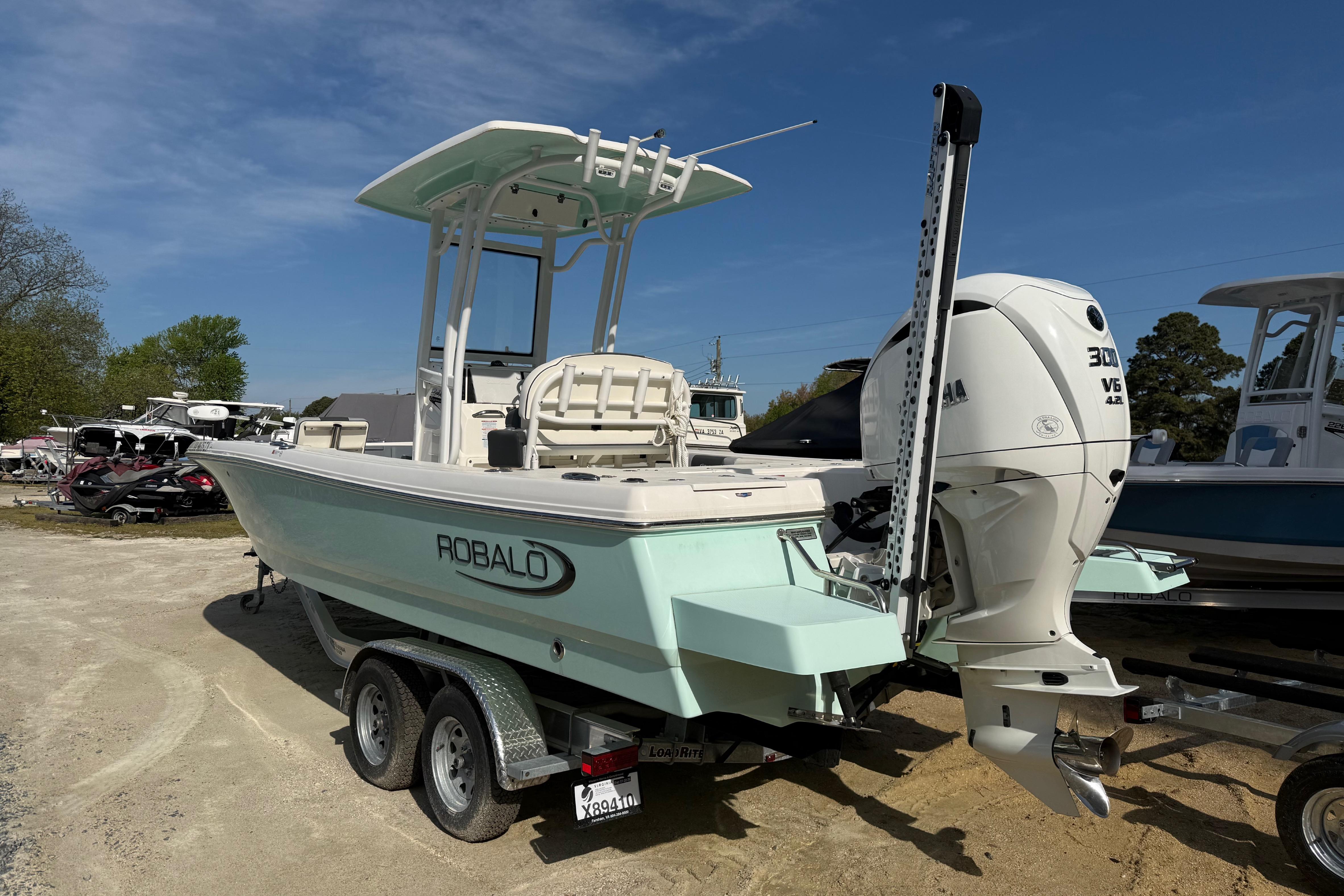 2023 Robalo 246 Cayman boat on trailer, featuring Yamaha 300 V6 engine, parked outdoors.