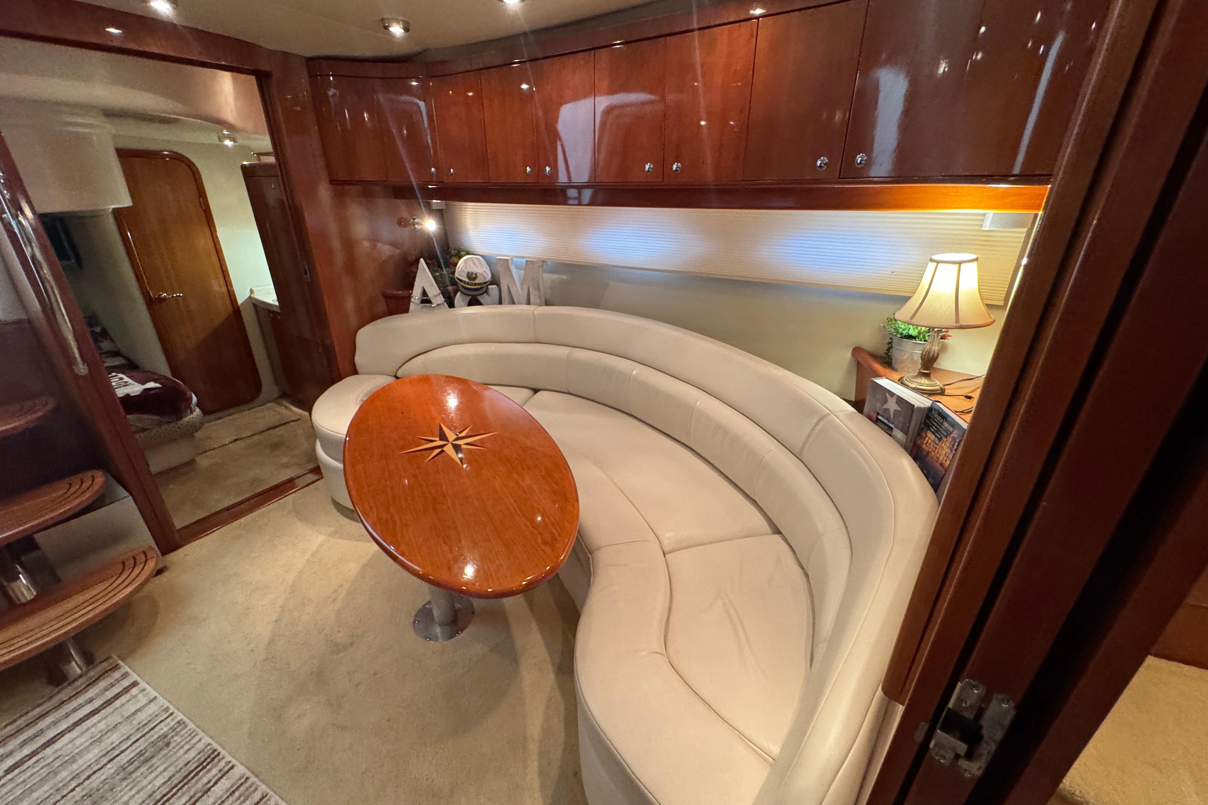 Luxurious 2005 Regal Commodore 4260 yacht interior with curved seating and elegant wood finishes.