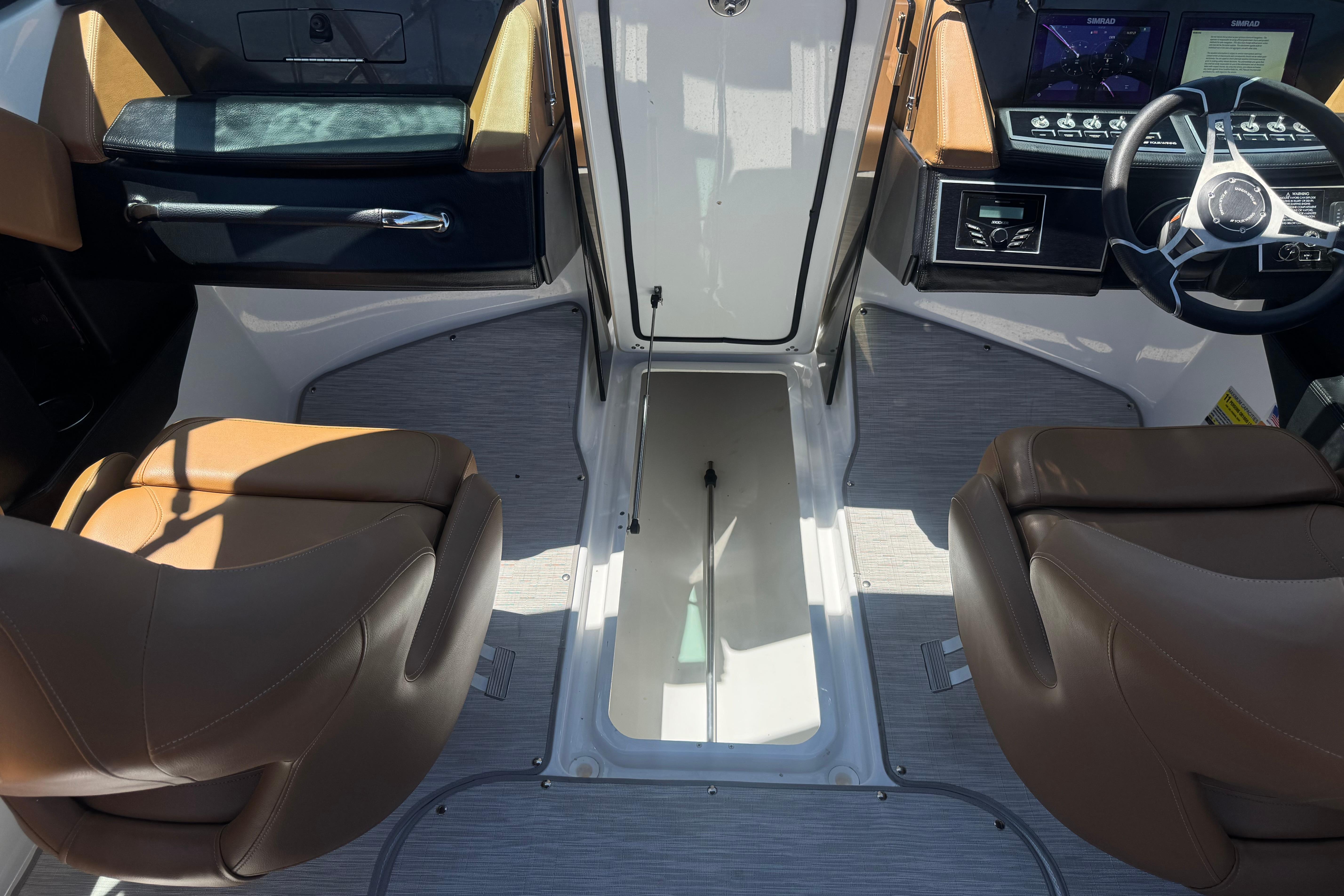 Interior of 2022 Four Winns H4 boat with brown seats and modern dashboard.