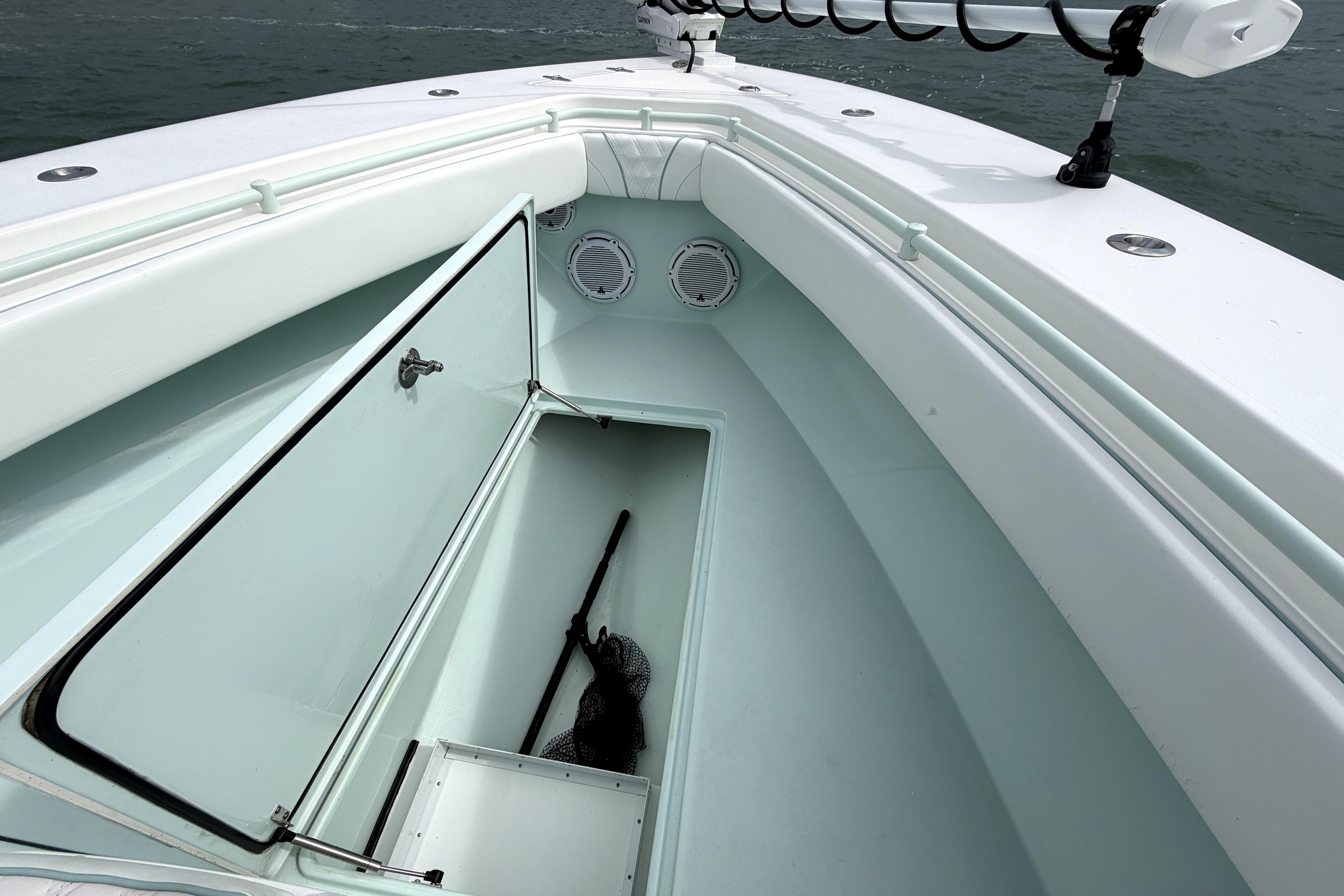 2019 Contender 30 ST boat with open storage compartment and fishing gear.