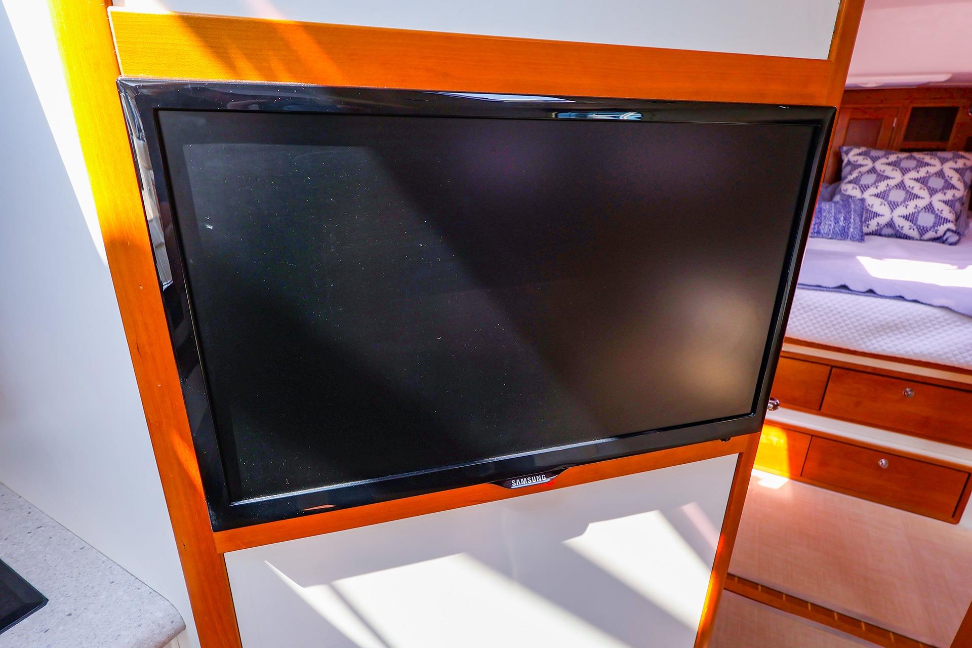 Flat-screen TV in 2010 MJM 40z Downeast yacht interior, near cozy sleeping area.