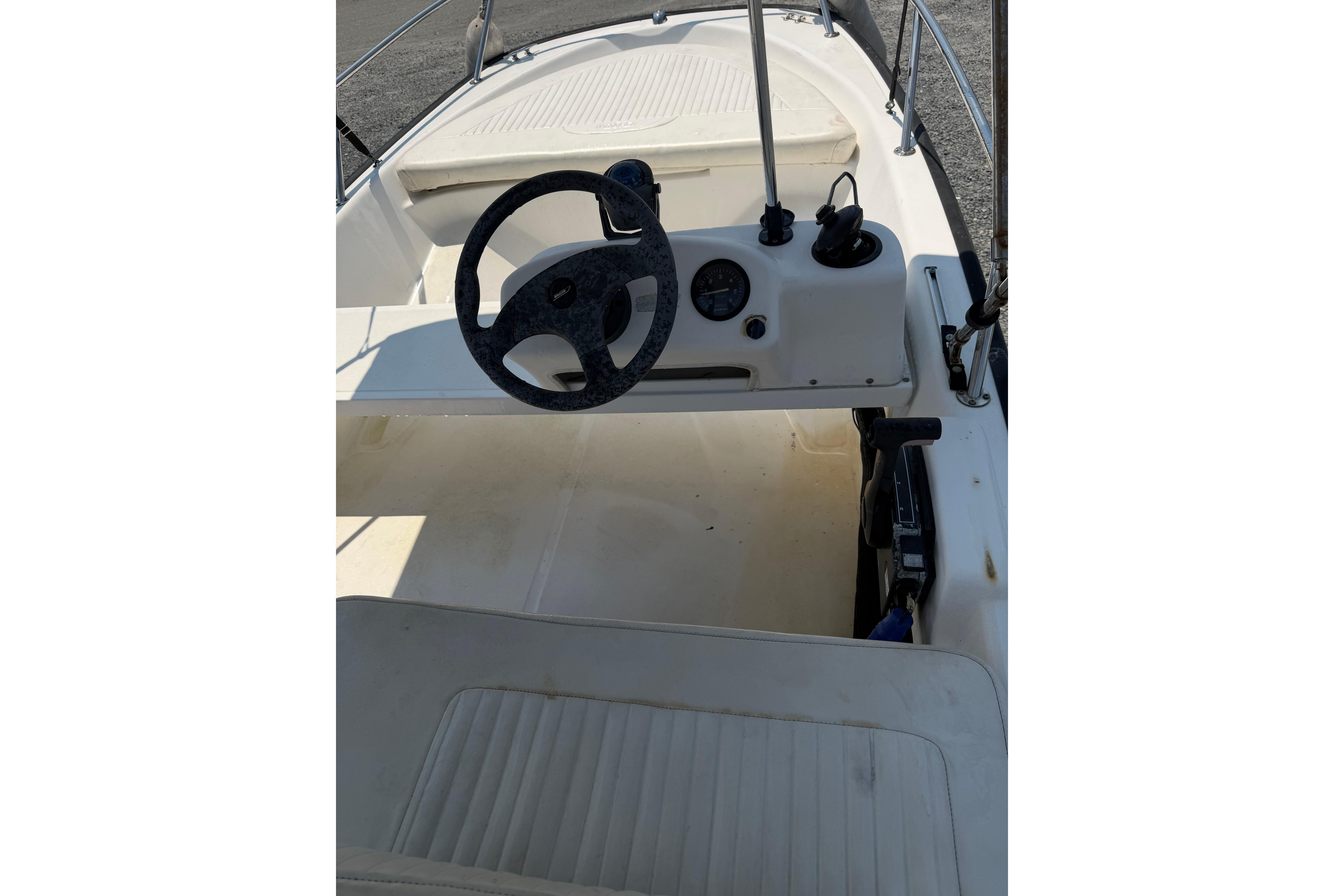 2003 Boston Whaler 130 Super Sport boat interior with steering wheel and controls.