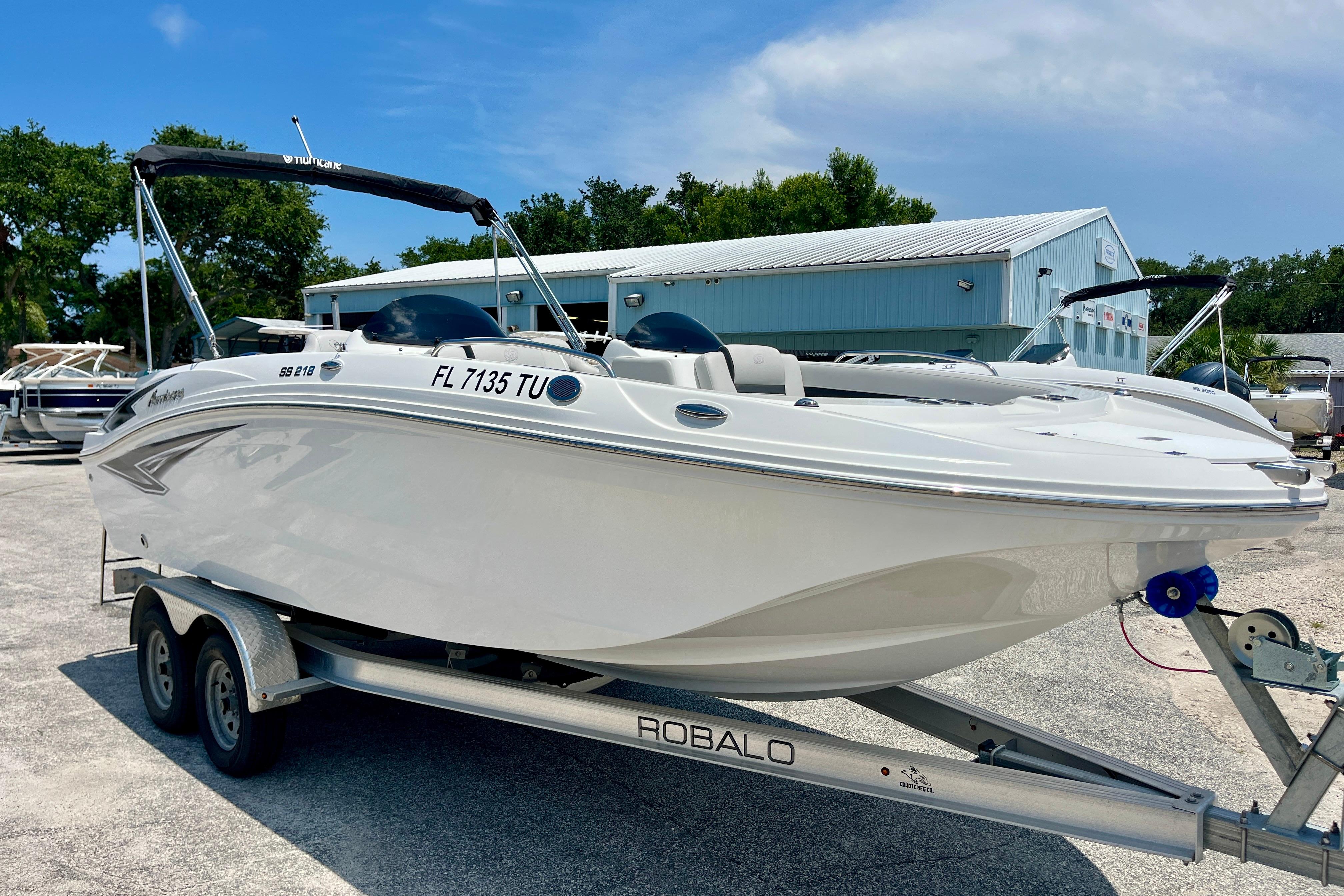 2024 Hurricane Sundeck Sport 218 OB boat on trailer, parked outdoors.