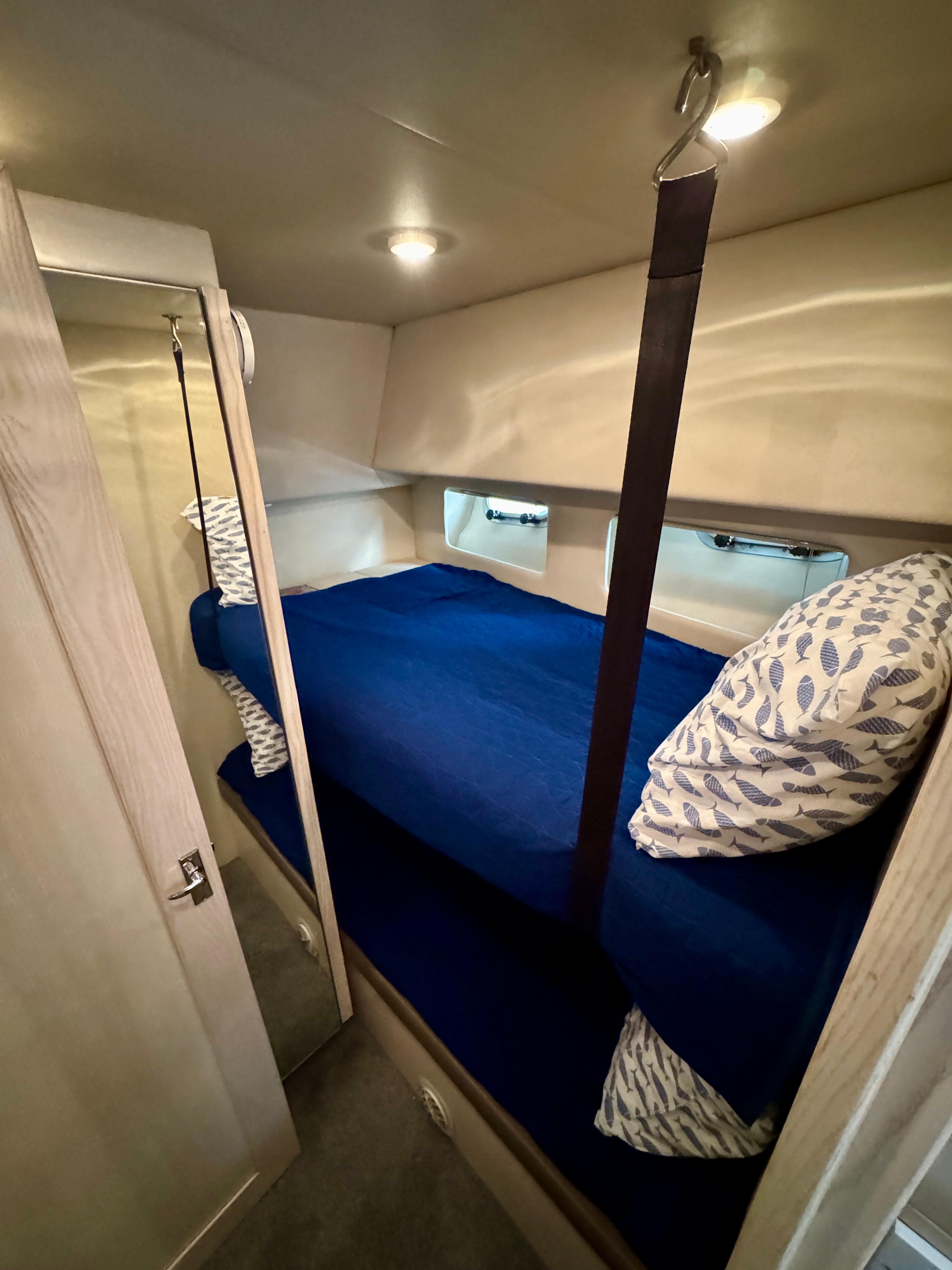 Cozy bunk beds in 1996 Bayliner 4788 Pilothouse cabin with blue bedding and patterned pillows.