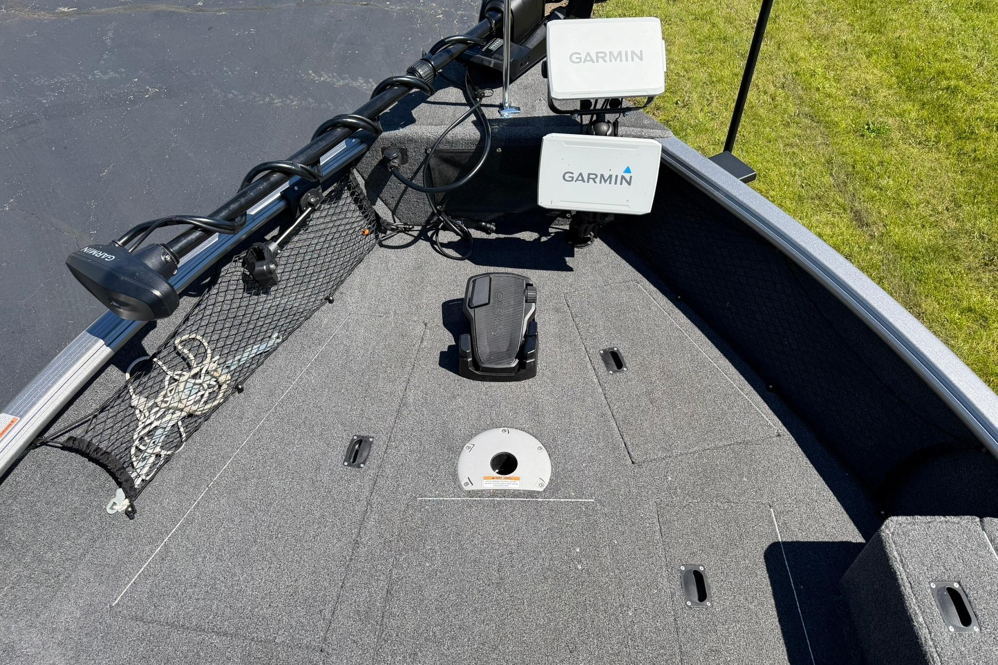 2024 Lund 1875 Impact XS Sport boat deck with Garmin electronics and storage compartments.