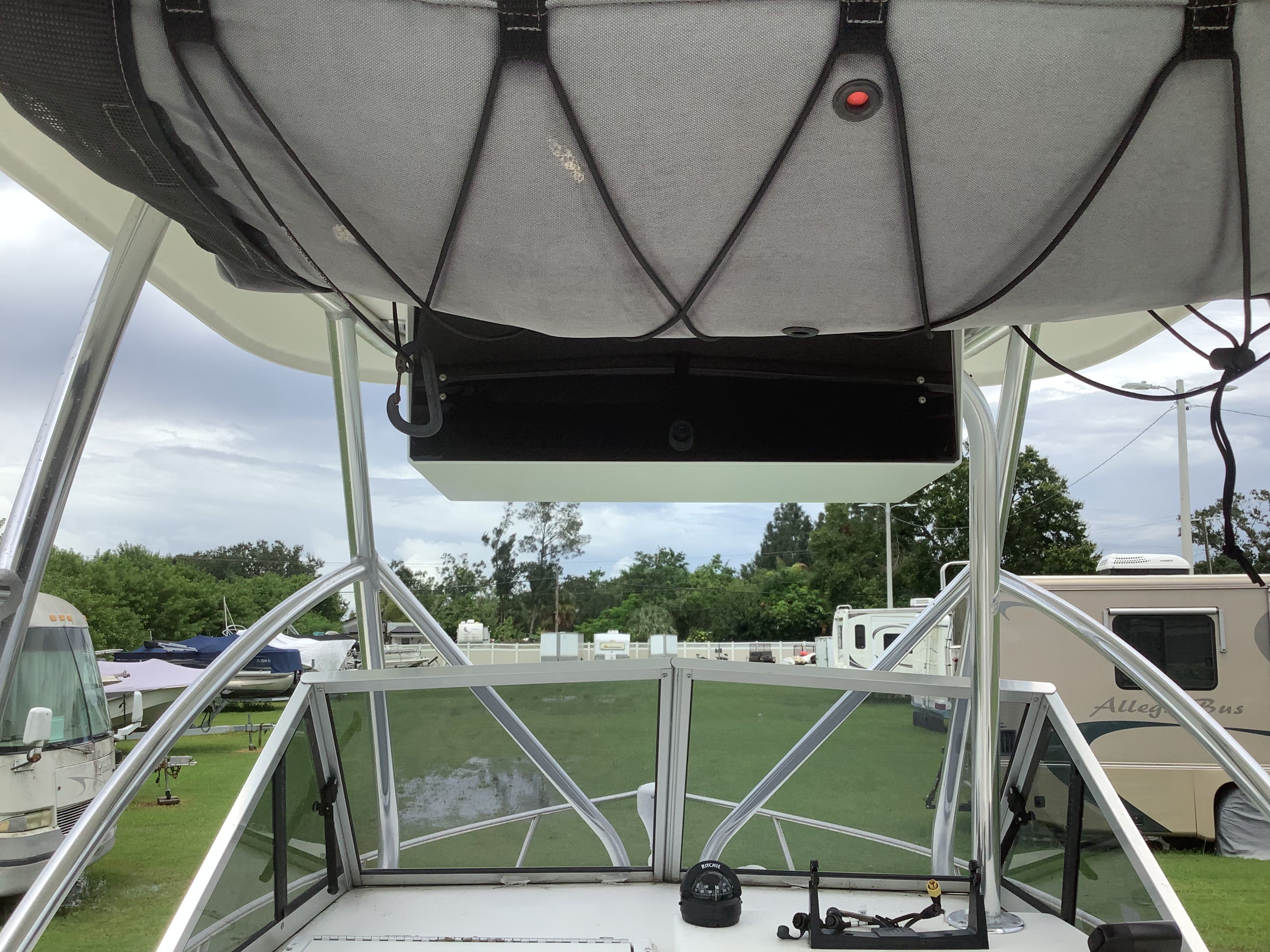 The image shows a boat's cockpit with a T-top and steering console.