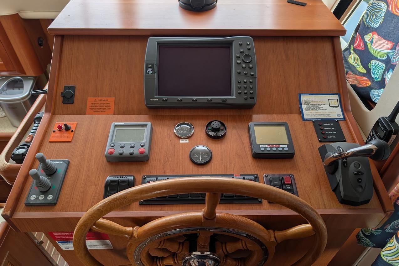 2008 Mainship 38 helm with navigation equipment and wooden steering wheel.