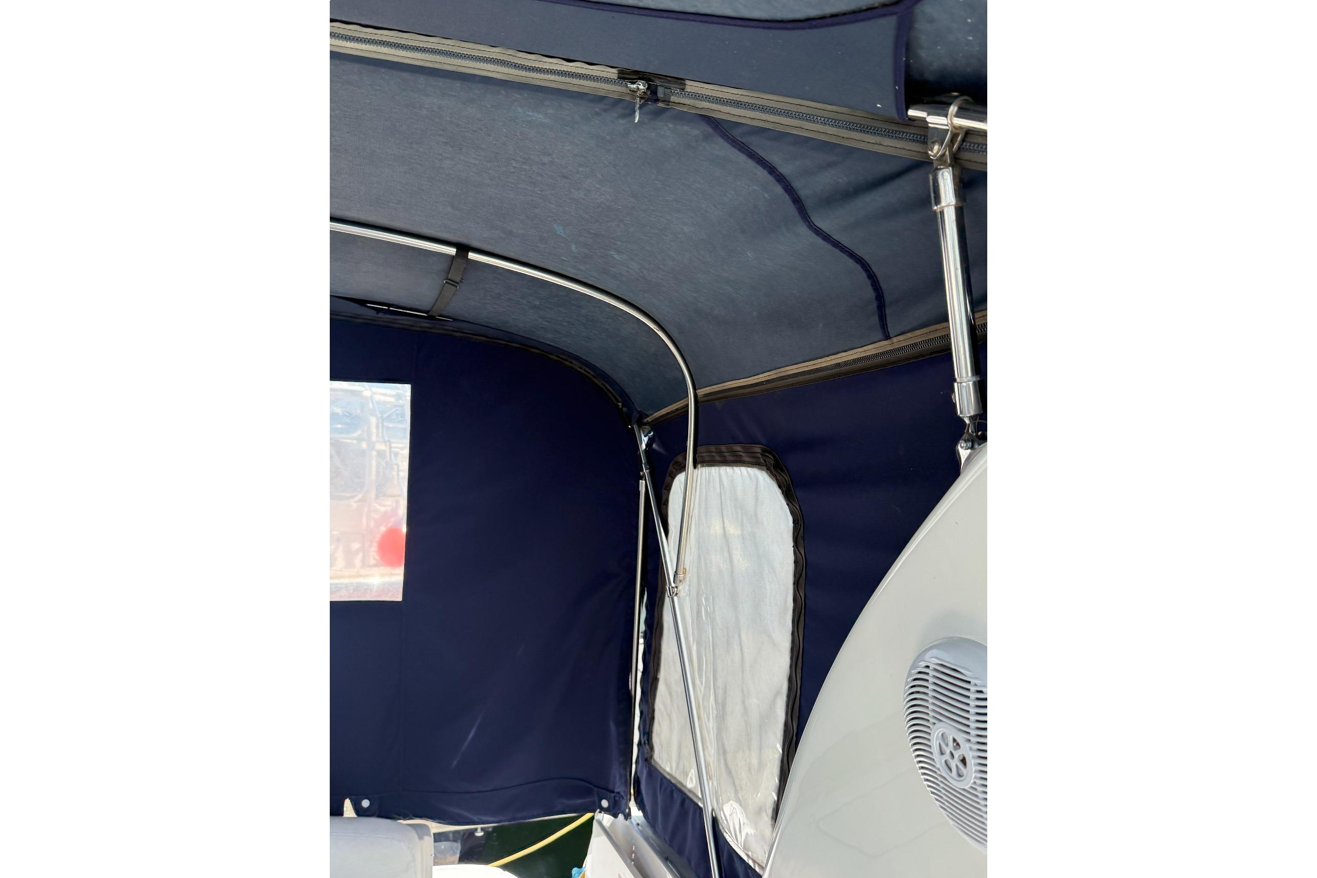 Interior view of a 2006 Sea Ray 300 Sundancer boat with blue canopy and speaker.