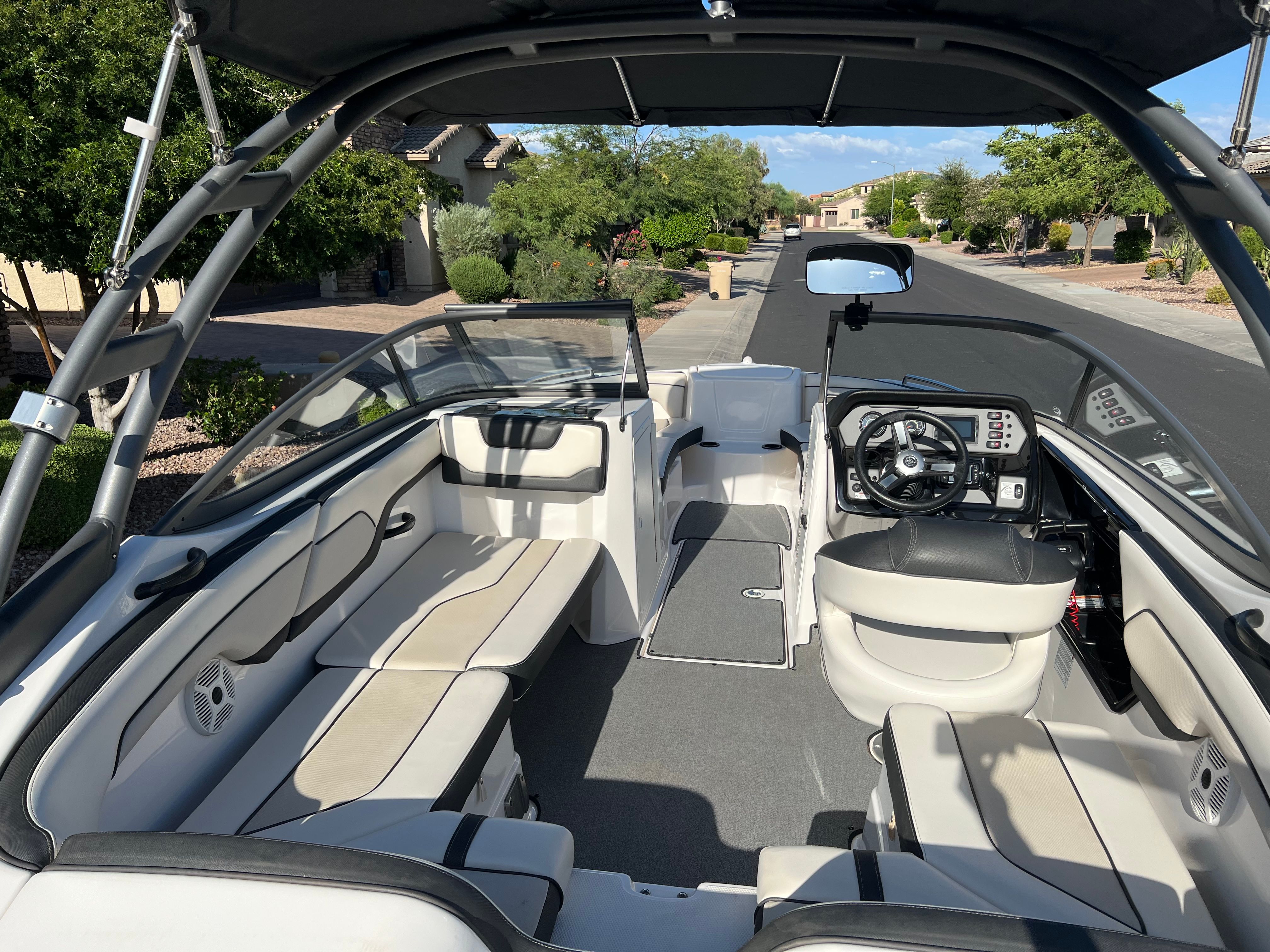 The image shows the interior of a 2018 Yamaha AR210 boat. It features white and gray seating and a modern dashboard.