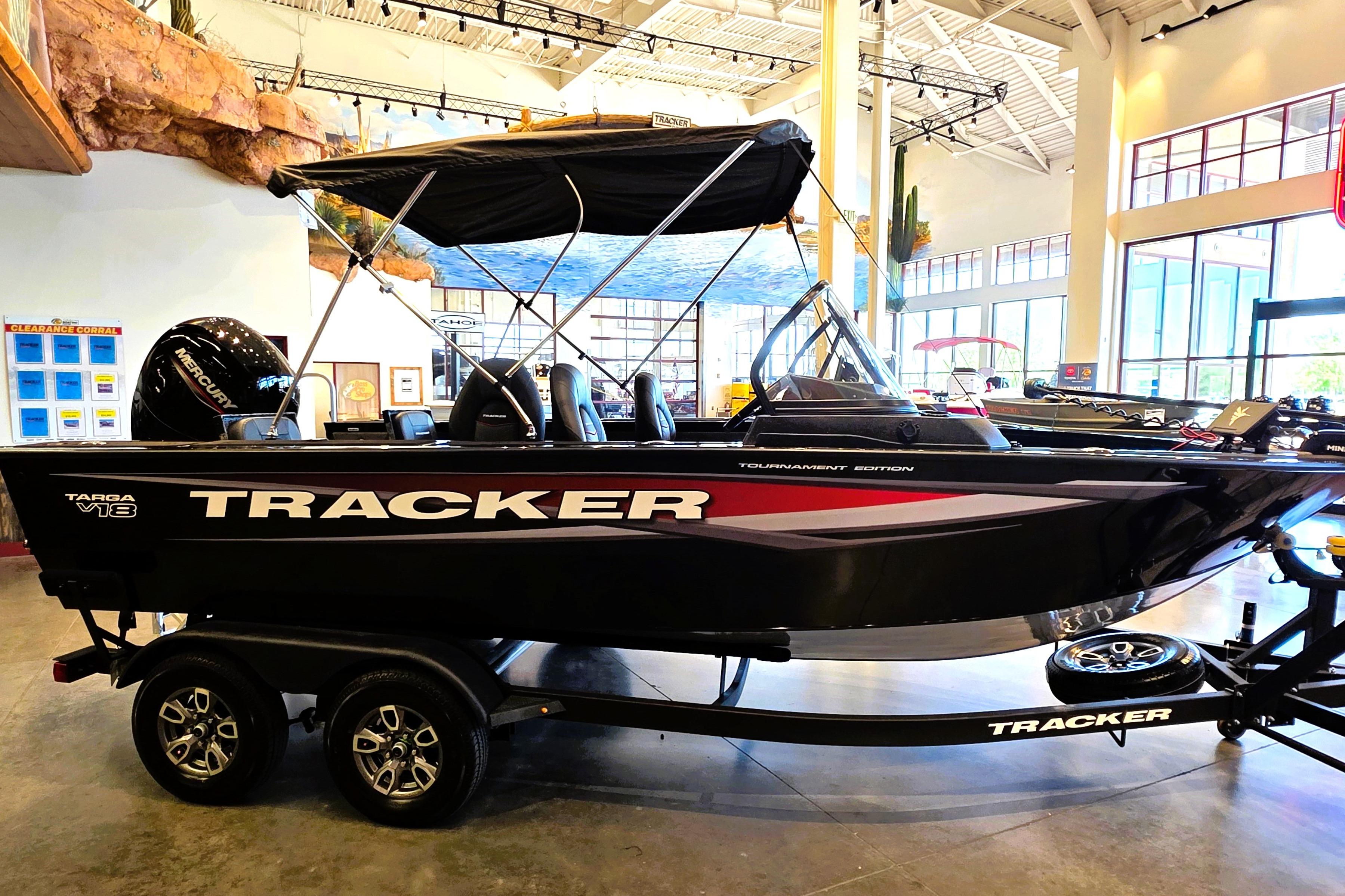 2026 Tracker Targa V-18 Combo boat displayed indoors, featuring sleek black design and trailer.