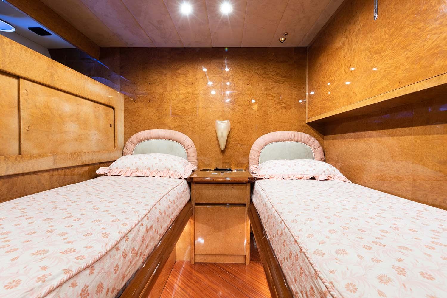 Luxurious twin cabin interior of 1992 Admiral 28 yacht with wood paneling and soft lighting.