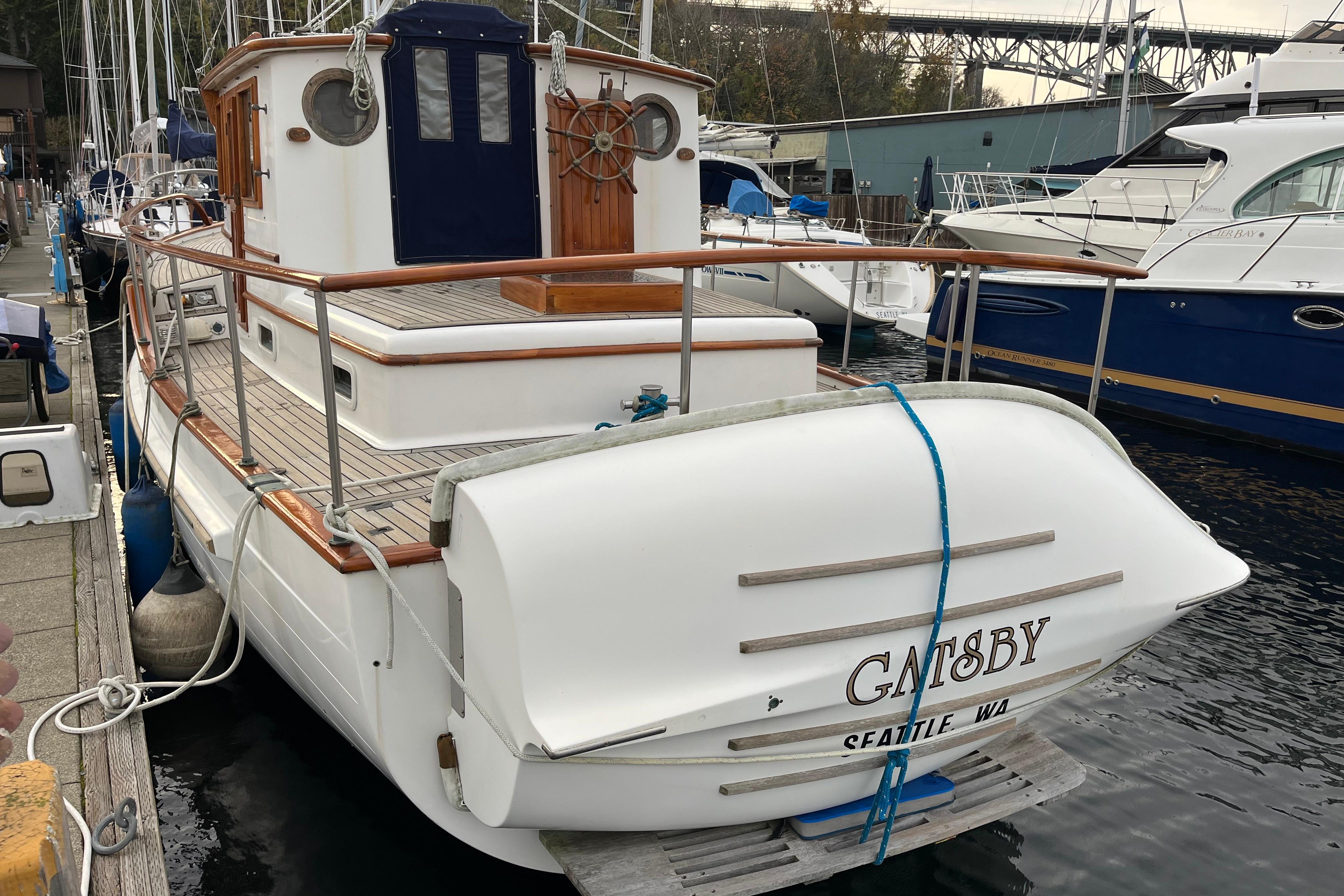1987 Liberty Gatsby boat docked in Seattle marina, featuring wooden railings and classic design.