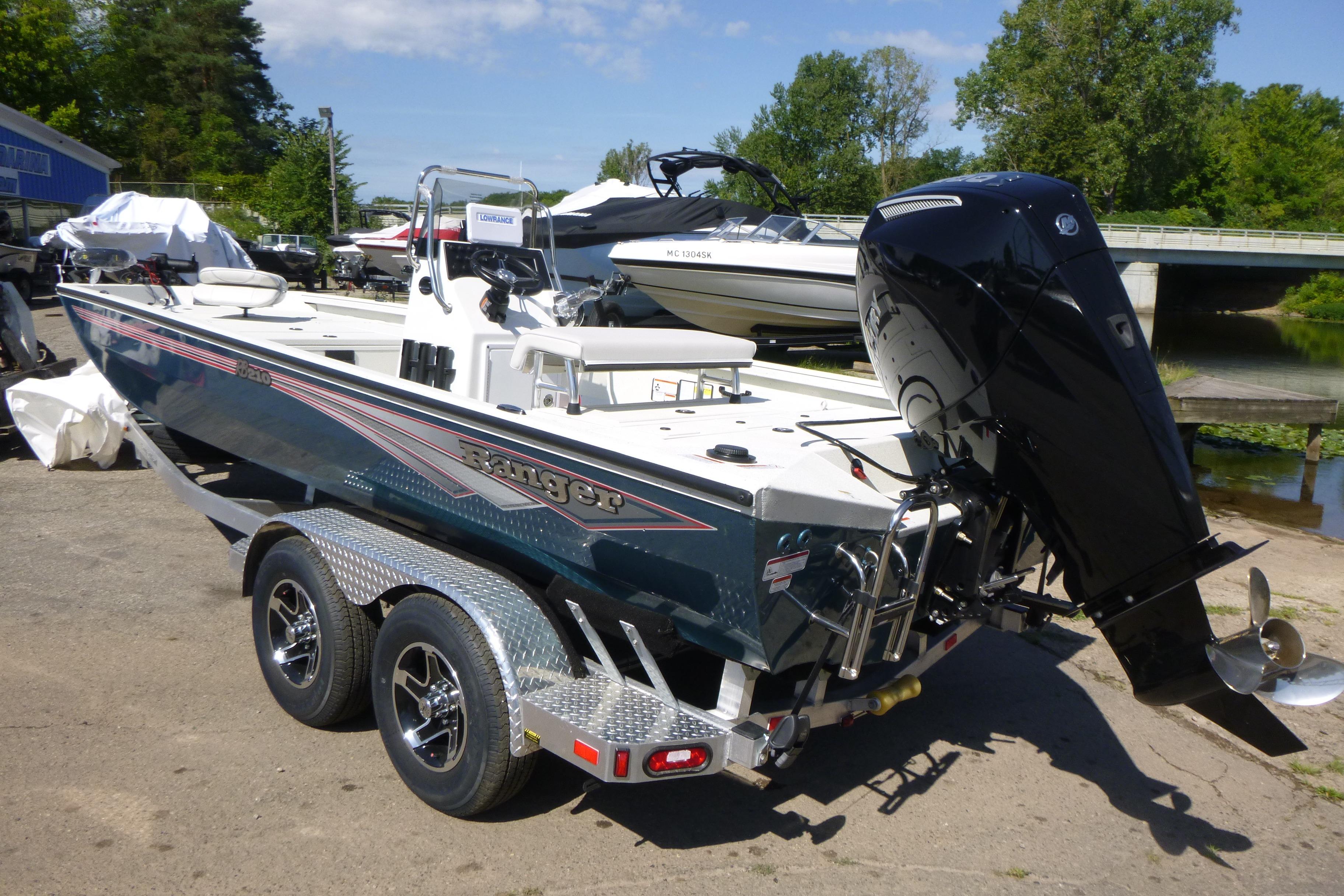 2025 Ranger RB210 boat with outboard motor on trailer, parked outdoors.