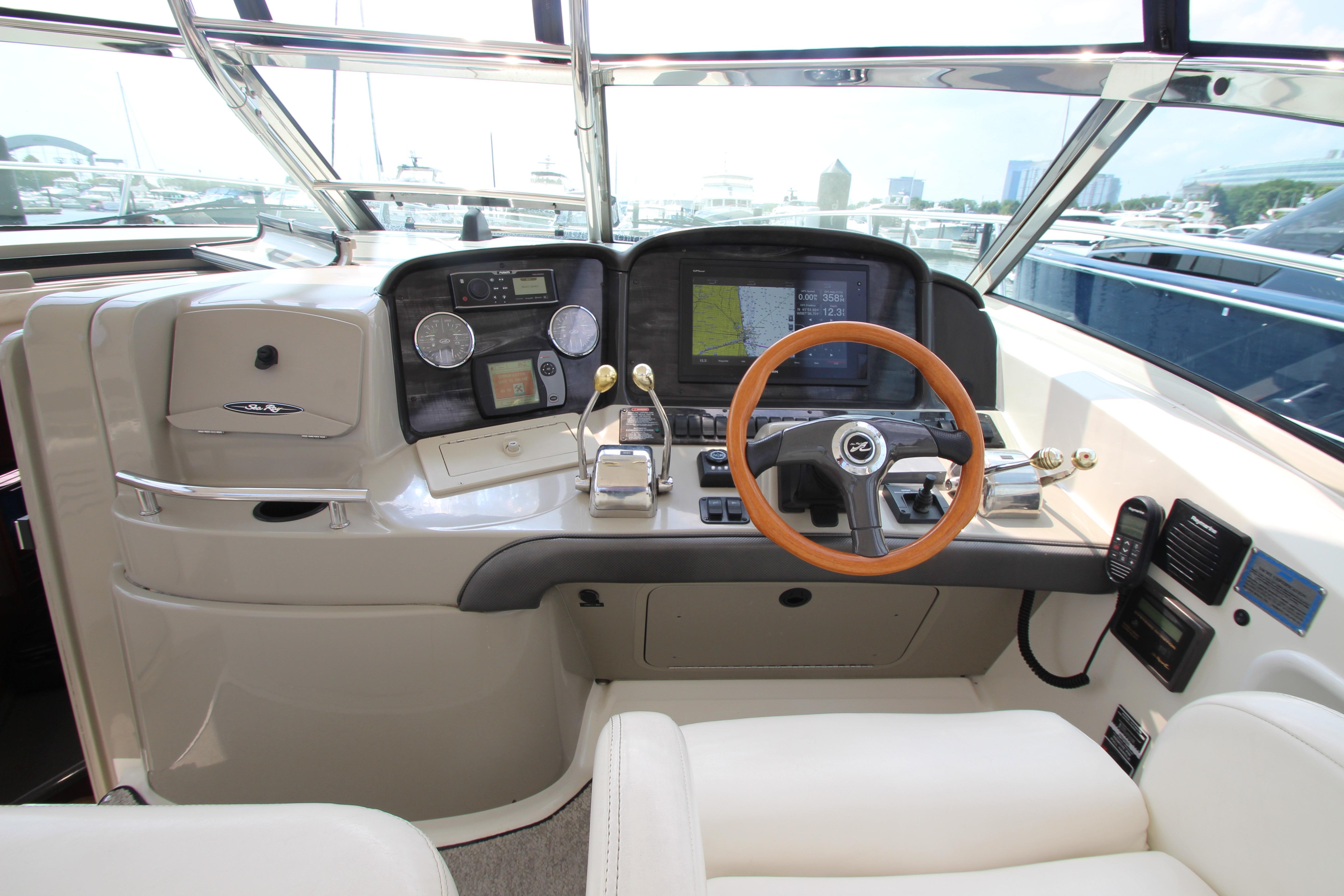 Helm of 2004 Sea Ray 40 Sundancer with modern navigation equipment and wooden steering wheel.