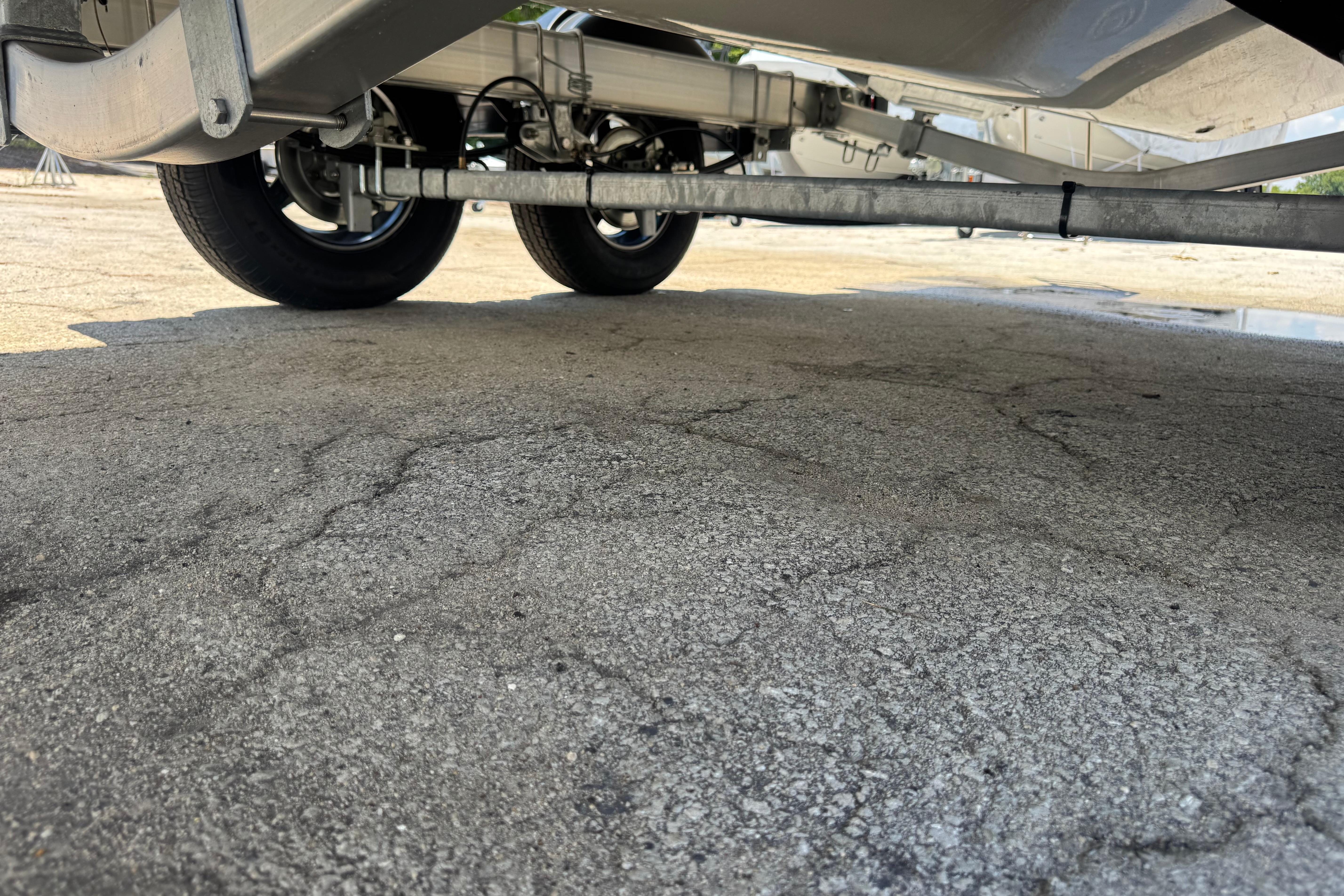 Underneath view of a 2026 Mako 214 Center Console trailer on pavement.