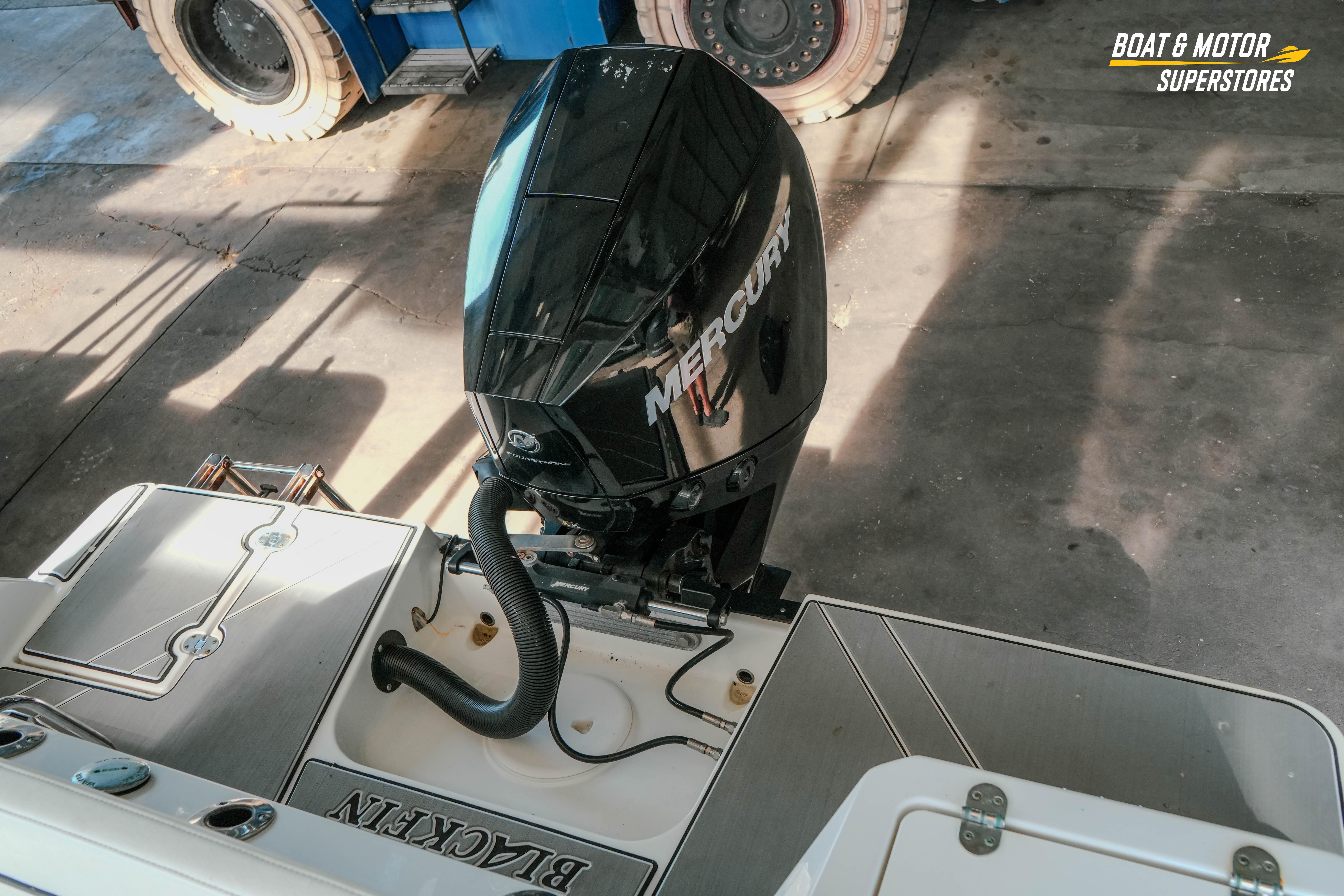 2022 Blackfin 222 CC boat with Mercury outboard motor in a showroom.
