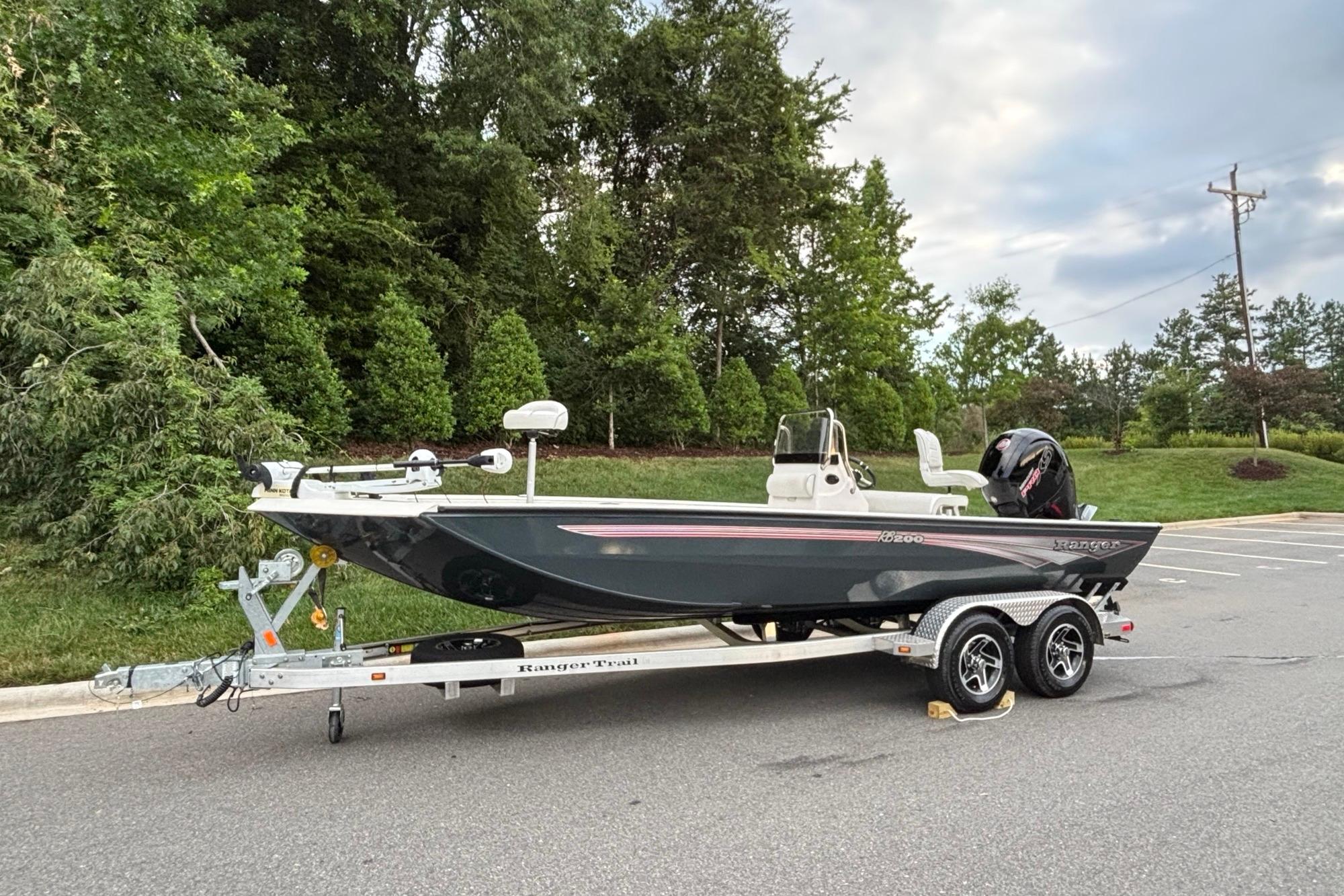2024 Ranger RB200 boat on trailer in parking lot, surrounded by trees.