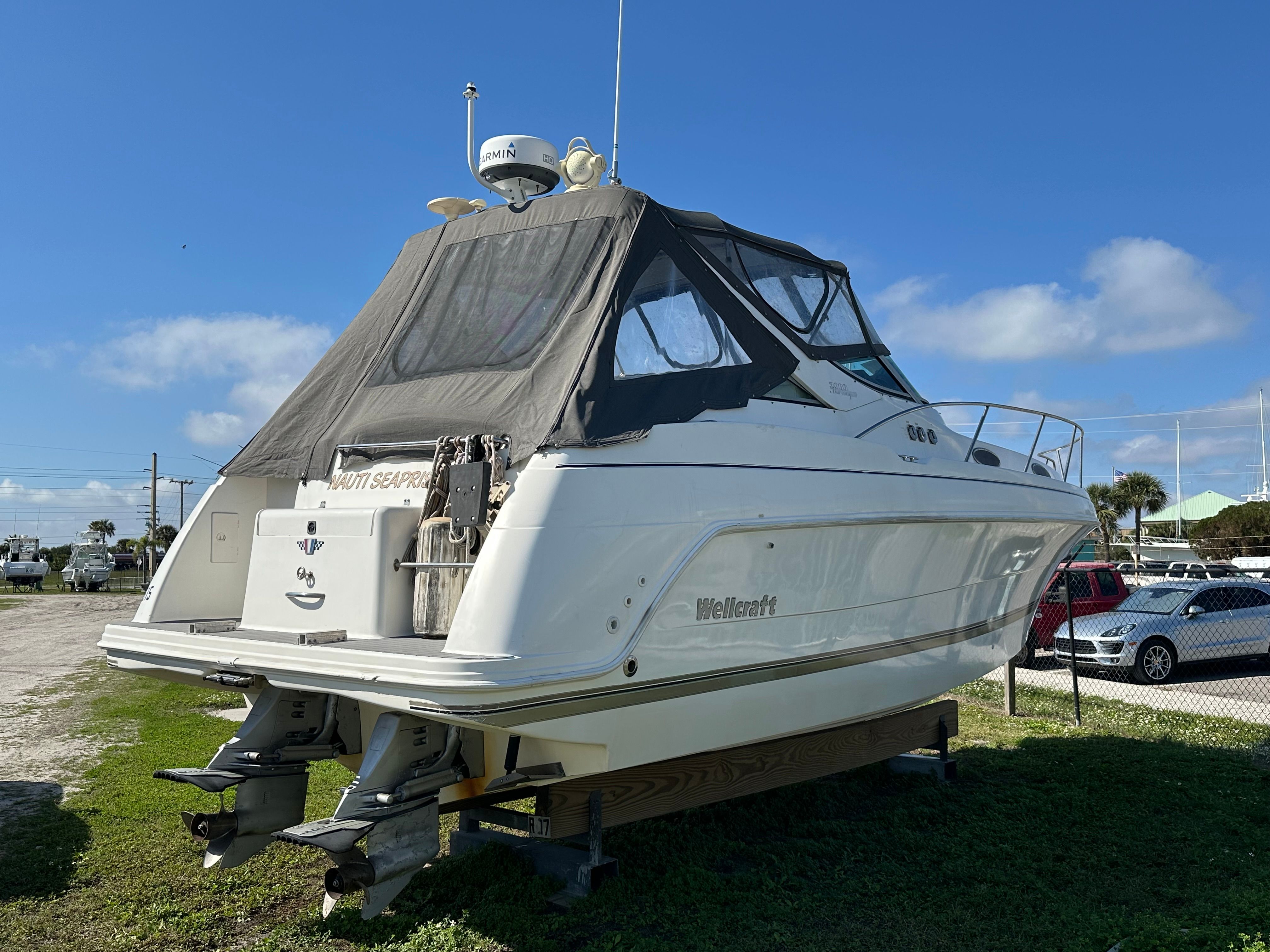 1999 Wellcraft 3000 Matrinique boat parked on grass.