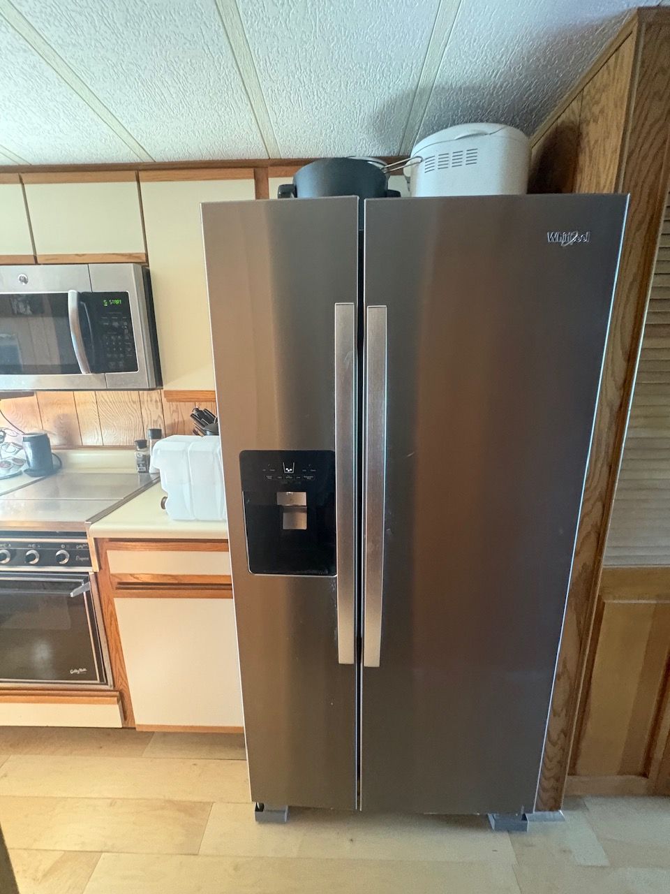 Kitchen with stainless steel refrigerator and microwave on a houseboat.