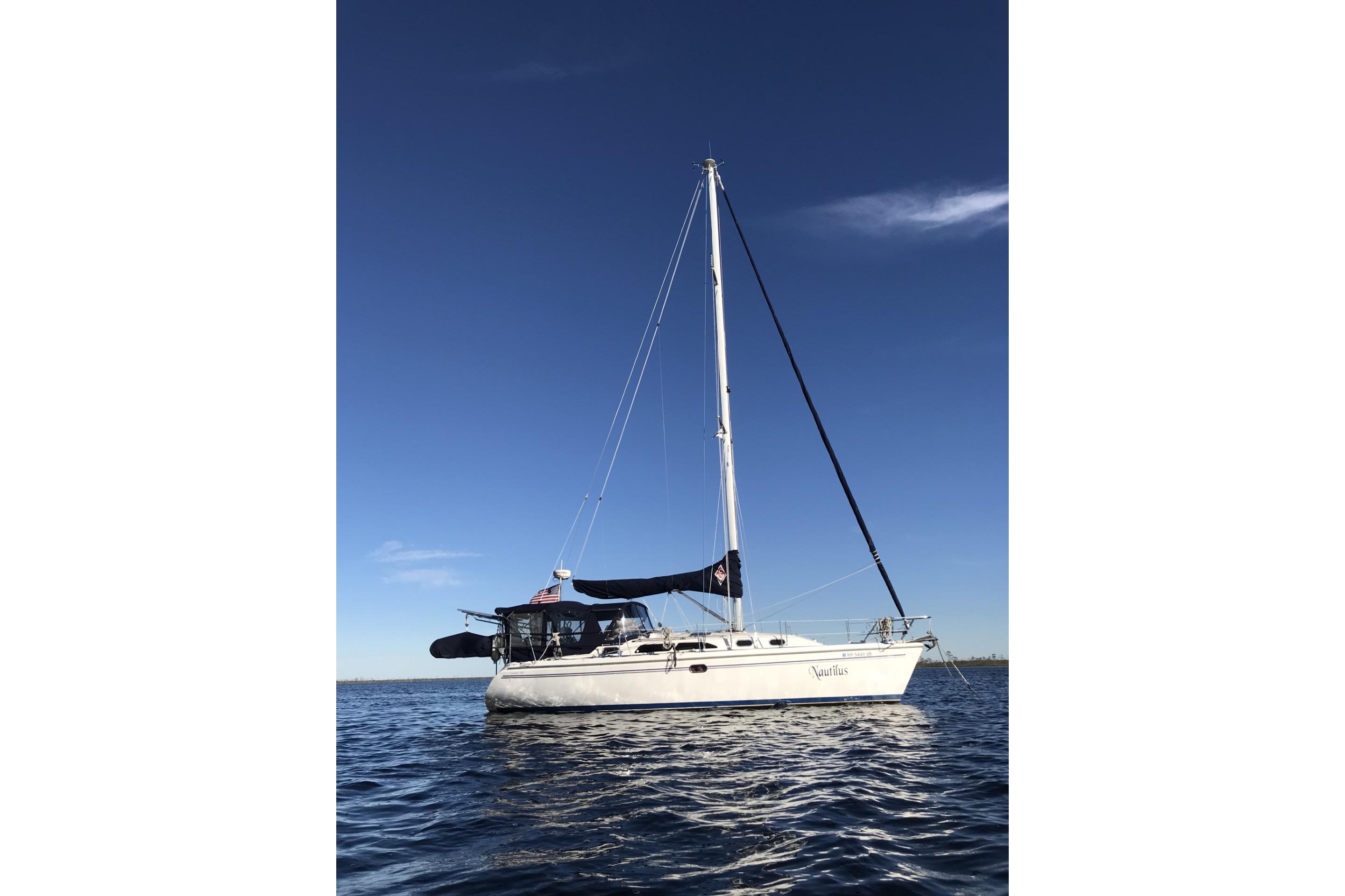 Catalina 350 sailboat from 2004 on calm water under clear blue sky.