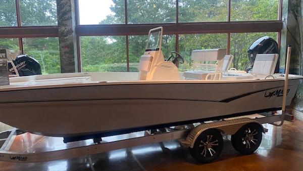 2023 Mako Pro Skiff 19 CC boat on a trailer in a showroom.