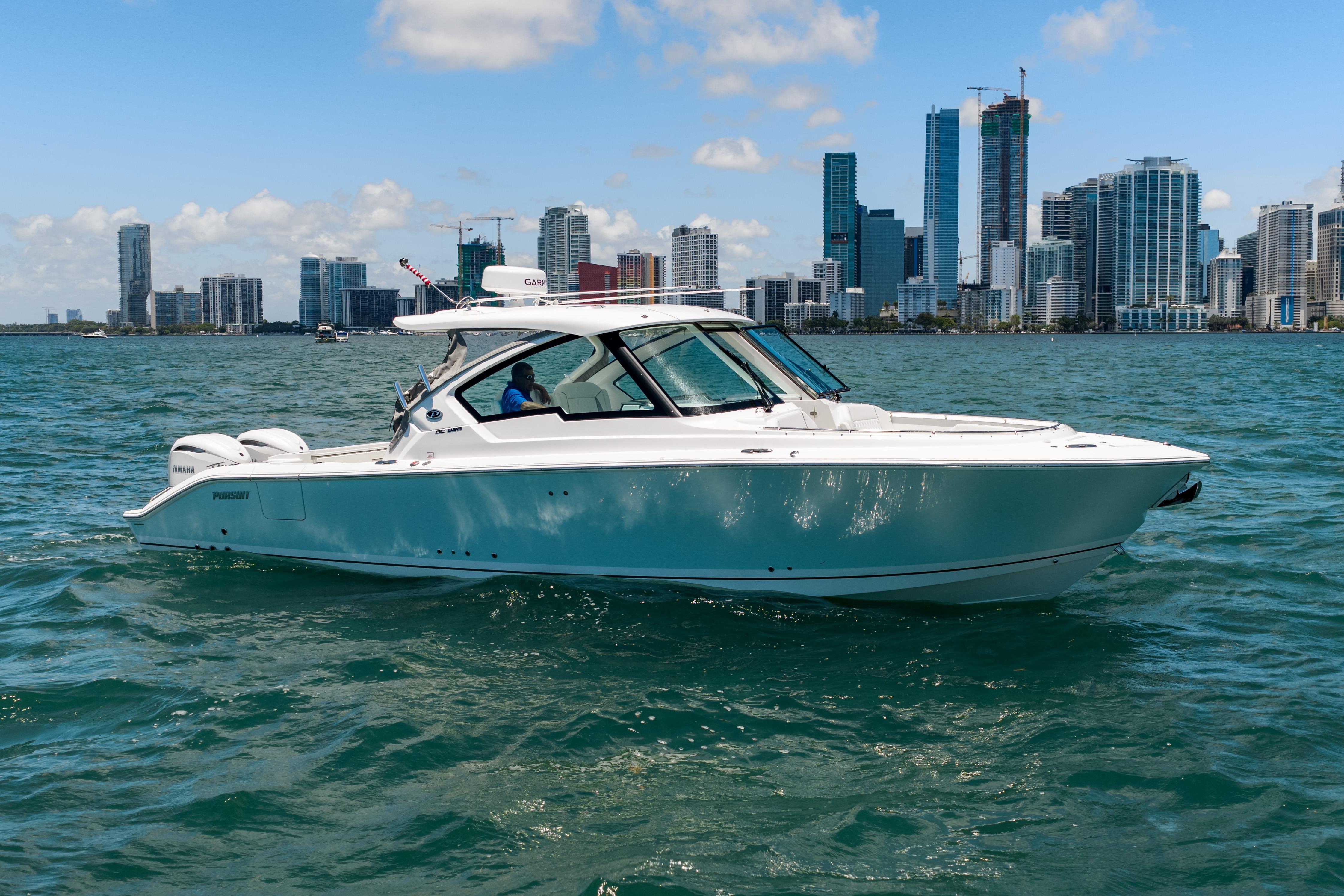 2026 Pursuit DC 326 Dual Console boat cruising near city skyline.