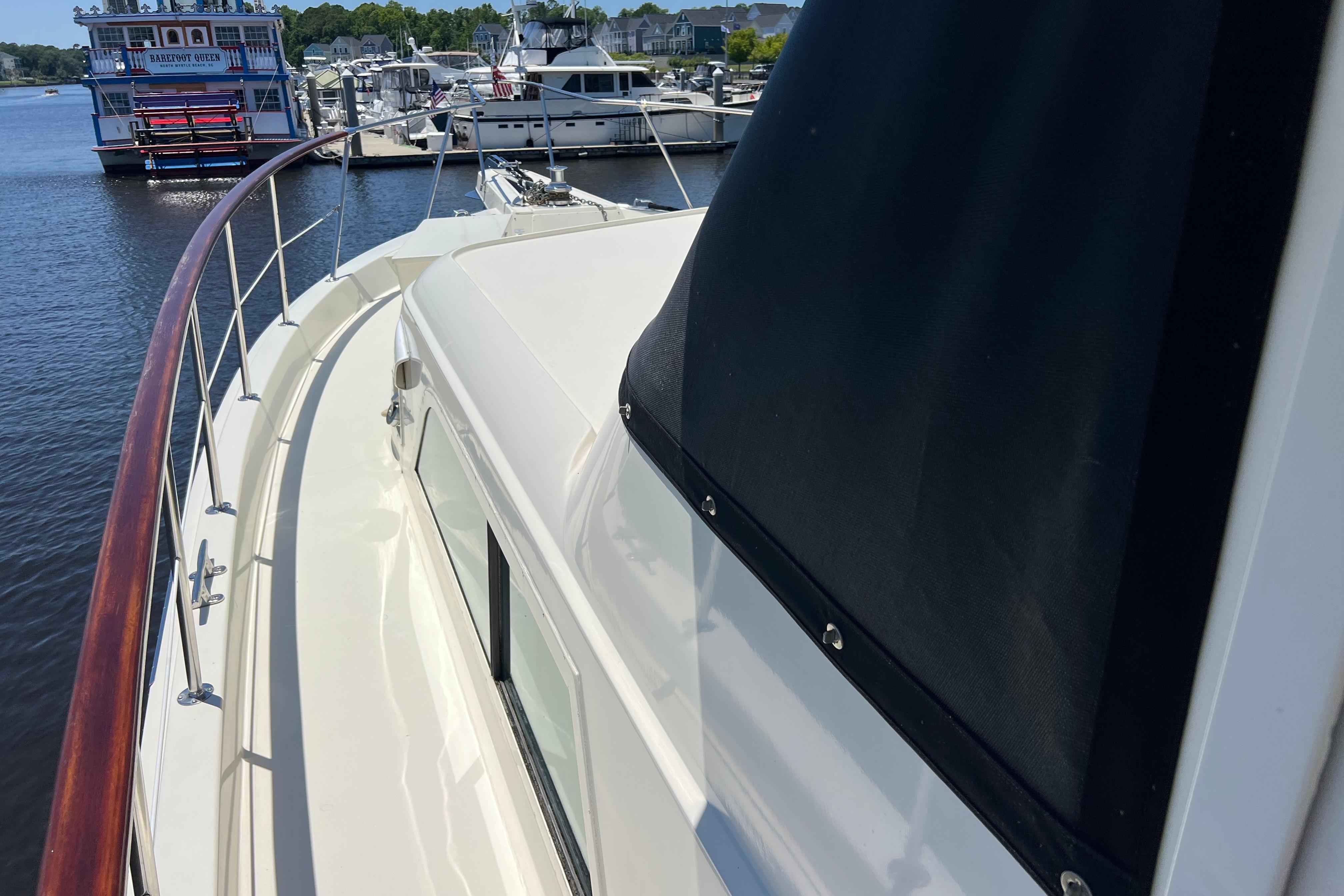 1987 Hatteras 70 Cockpit Motor Yacht docked at marina, showcasing sleek deck design.