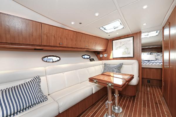 2008 Tiara Yachts 4200 Open interior with white seating, wooden accents, and striped pillows.