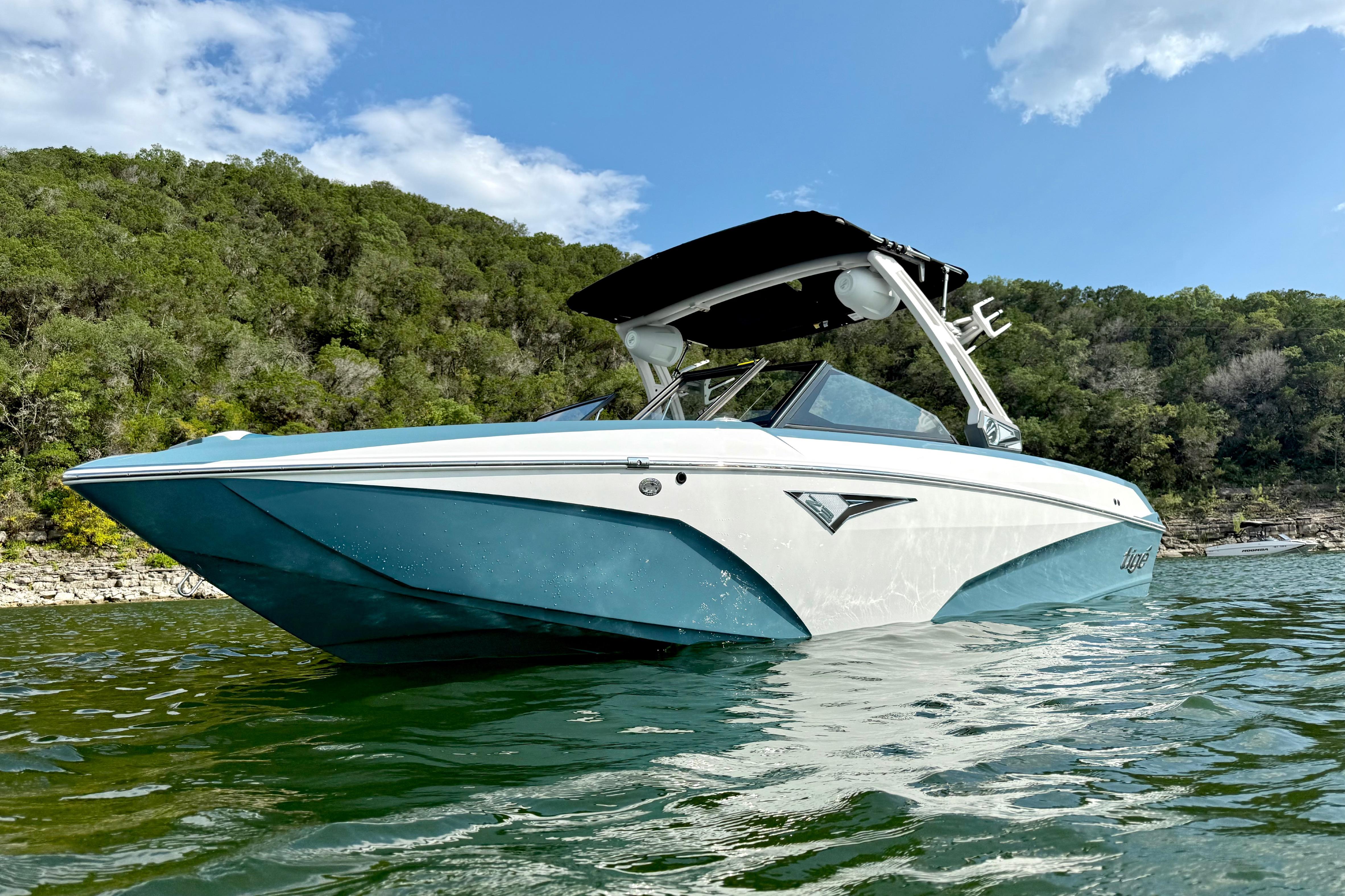 2021 Tige Z3 boat on a lake with lush green hills in the background.
