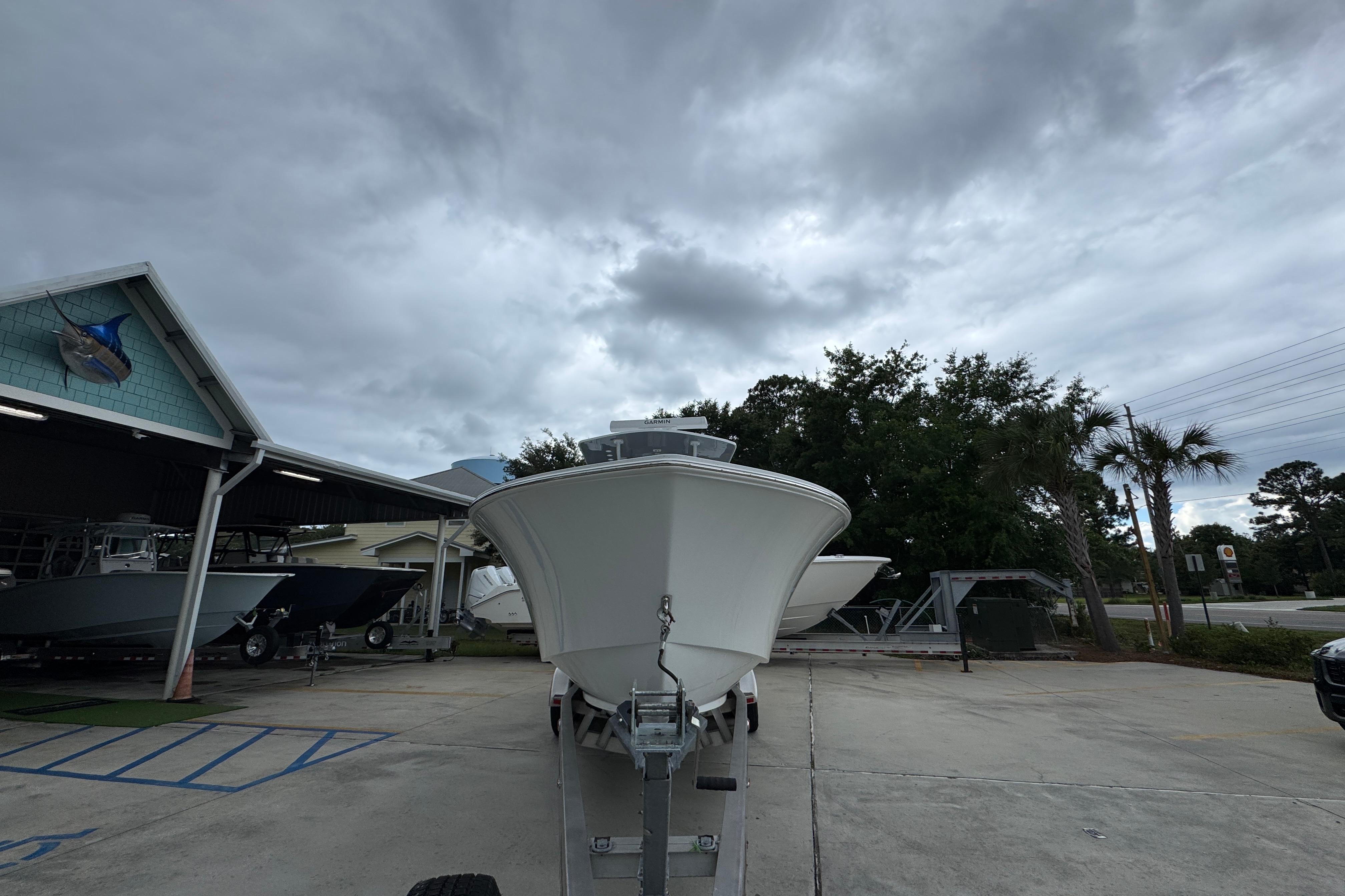 2026 Invincible 33 Open Fisherman boat on trailer under cloudy sky.