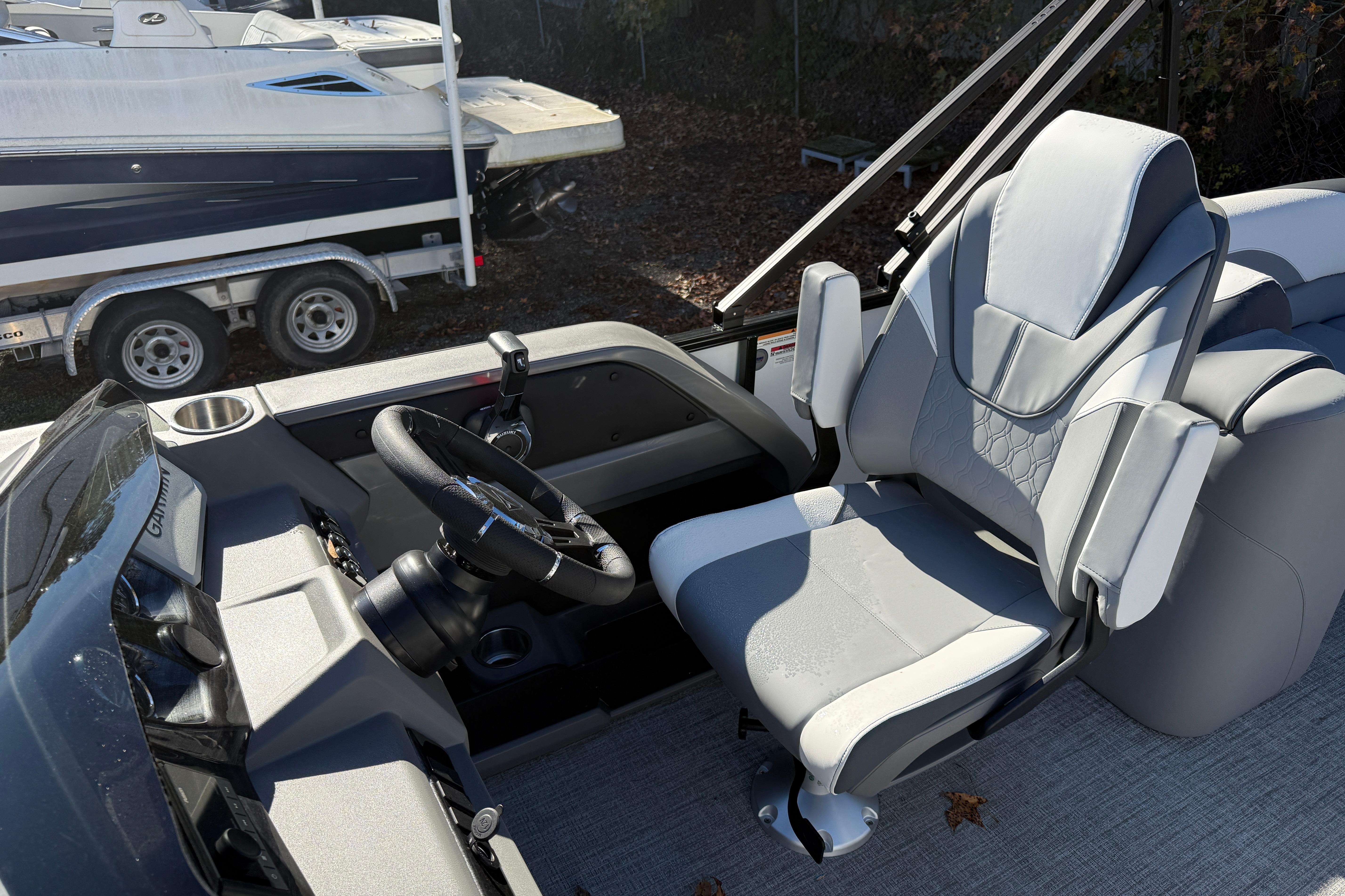 2026 Tahoe Pontoon LTZ Quad Lounger interior with steering wheel and captain's chair.
