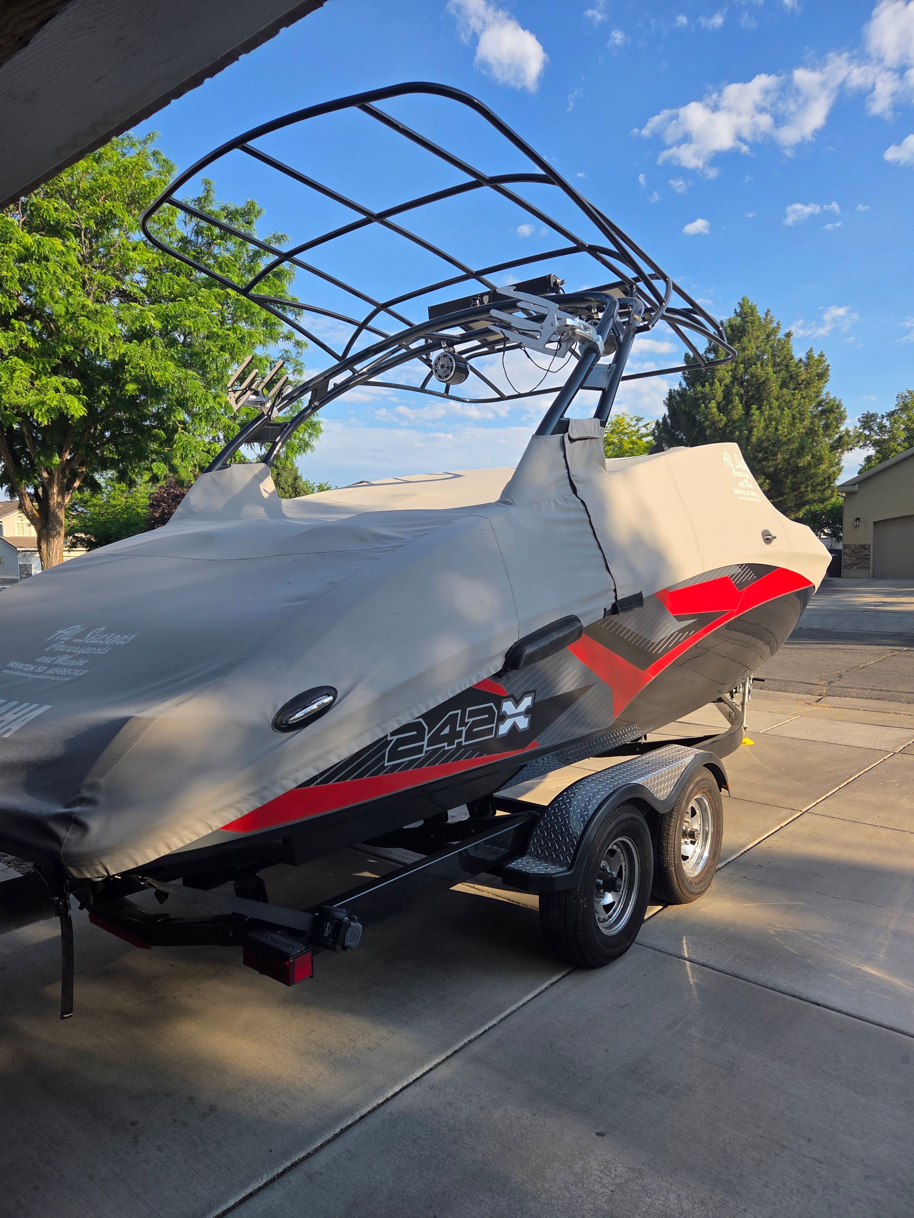 A 2016 Yamaha 242X E-Series boat on a trailer, covered with a protective cover.