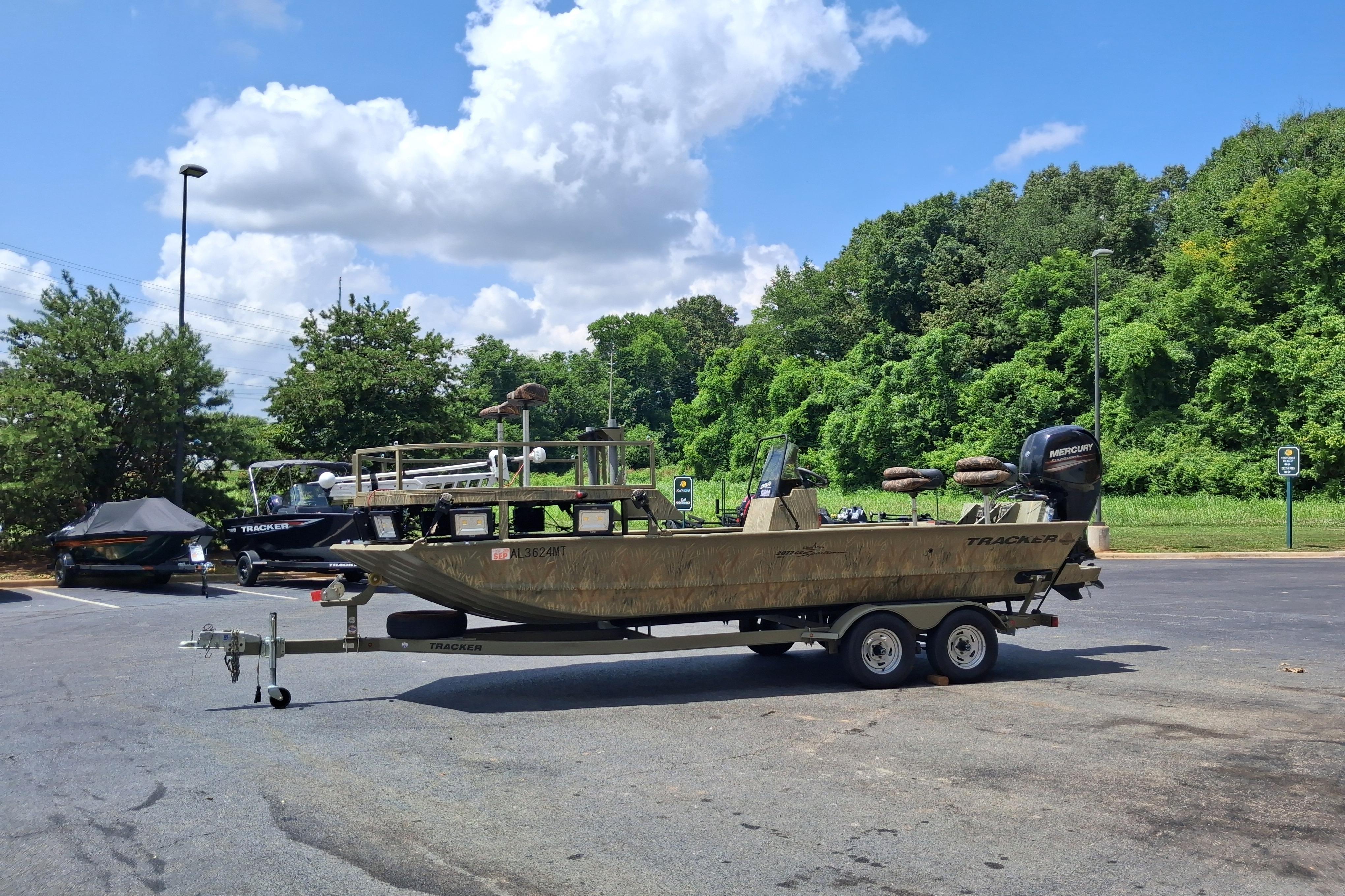 2016 Tracker Grizzly 2072 CC Sportsman boat on trailer in parking lot.