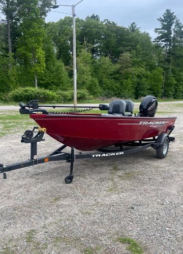 2025 Tracker Super Guide V-16 T boat on trailer, parked outdoors.