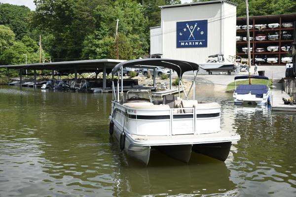 2023 Bennington 22 SXCW pontoon boat docked at a marina with covered boat storage.