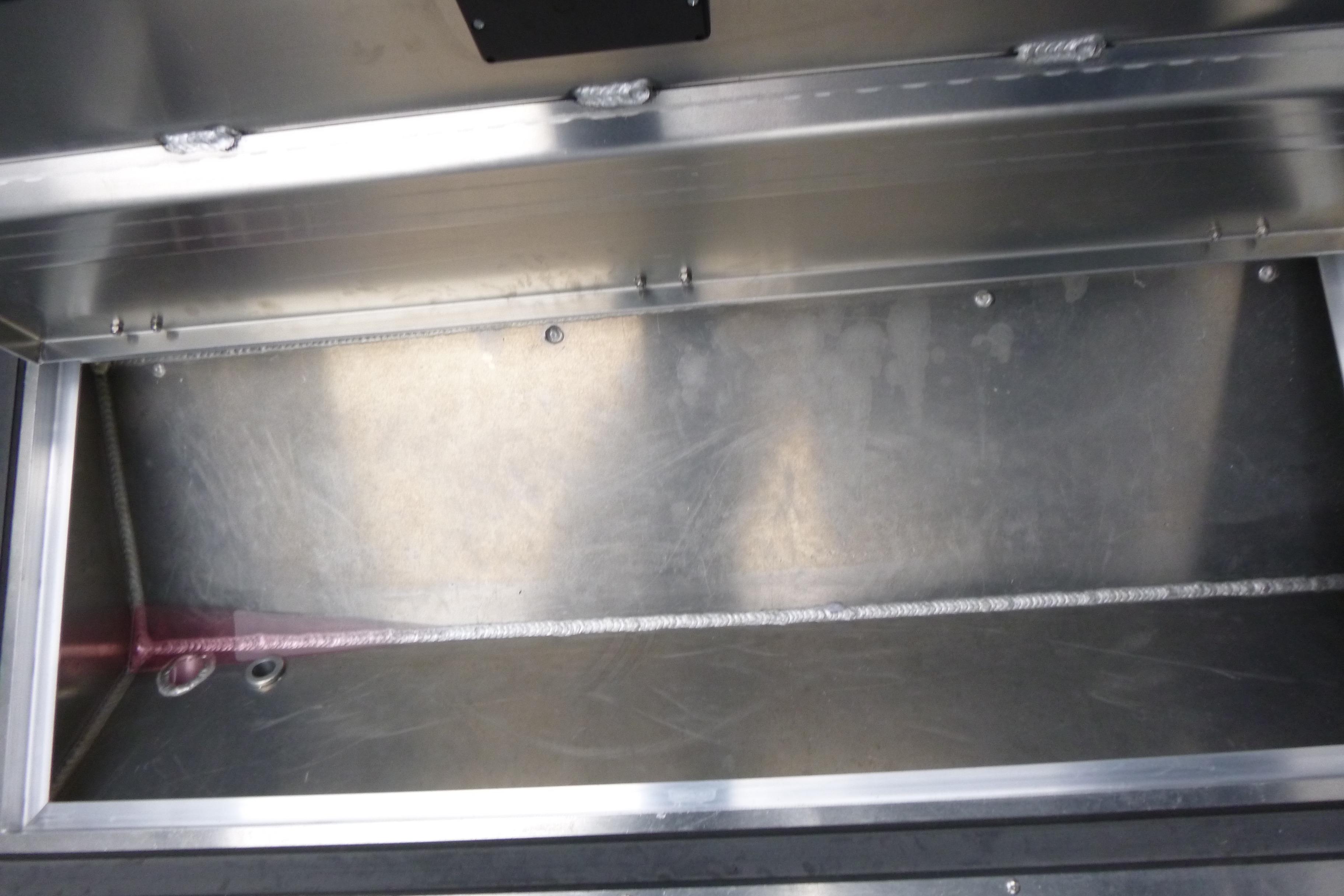 Open storage compartment in 2026 KingFisher 25 XAC boat, showcasing metal interior.